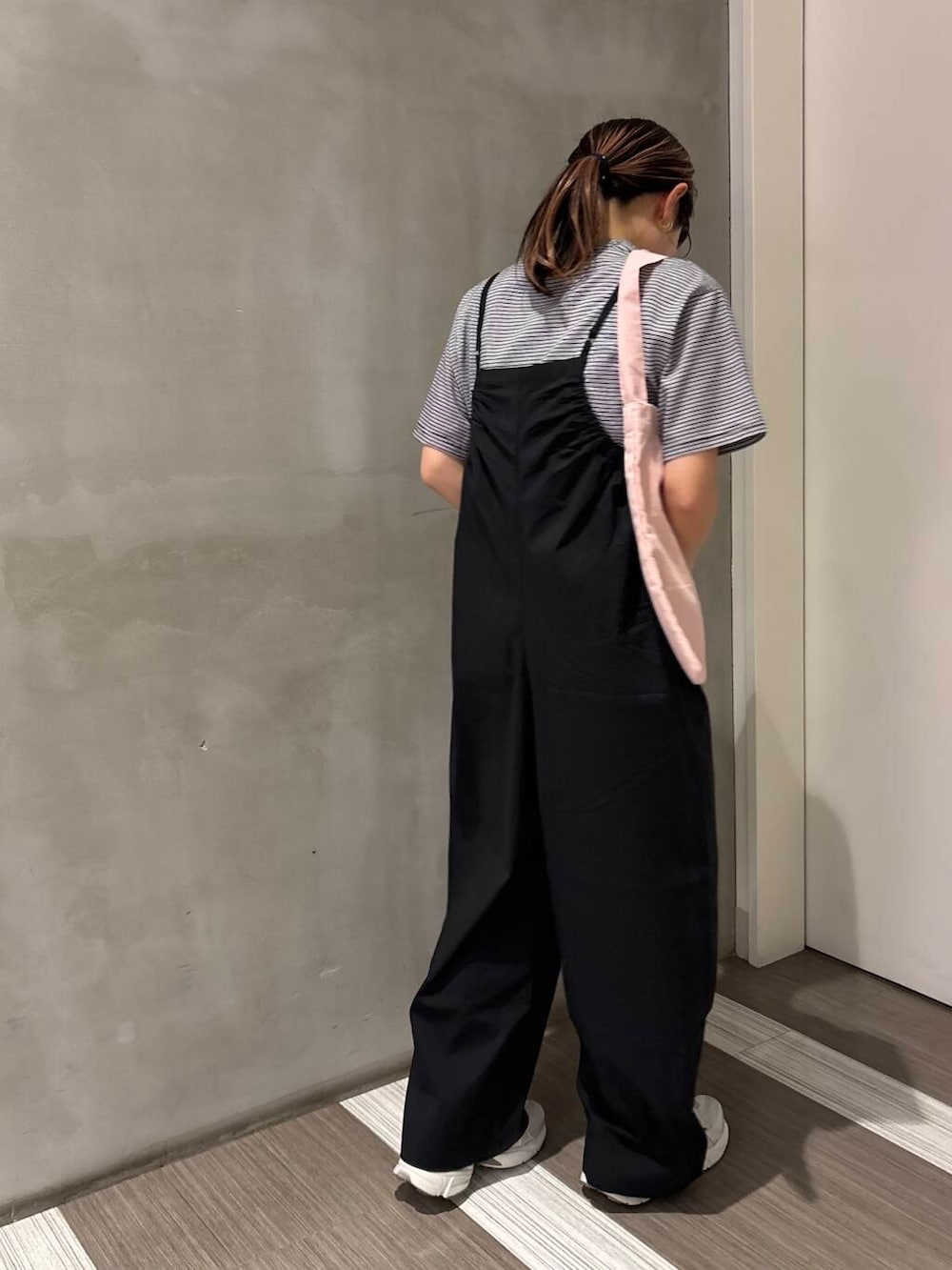 シルバー系のスニーカー、ブラック系のサロペット/オーバーオール、ピンク系のエコバッグ/サブバッグを着用したレディースの春コーディネートの2枚目の写真