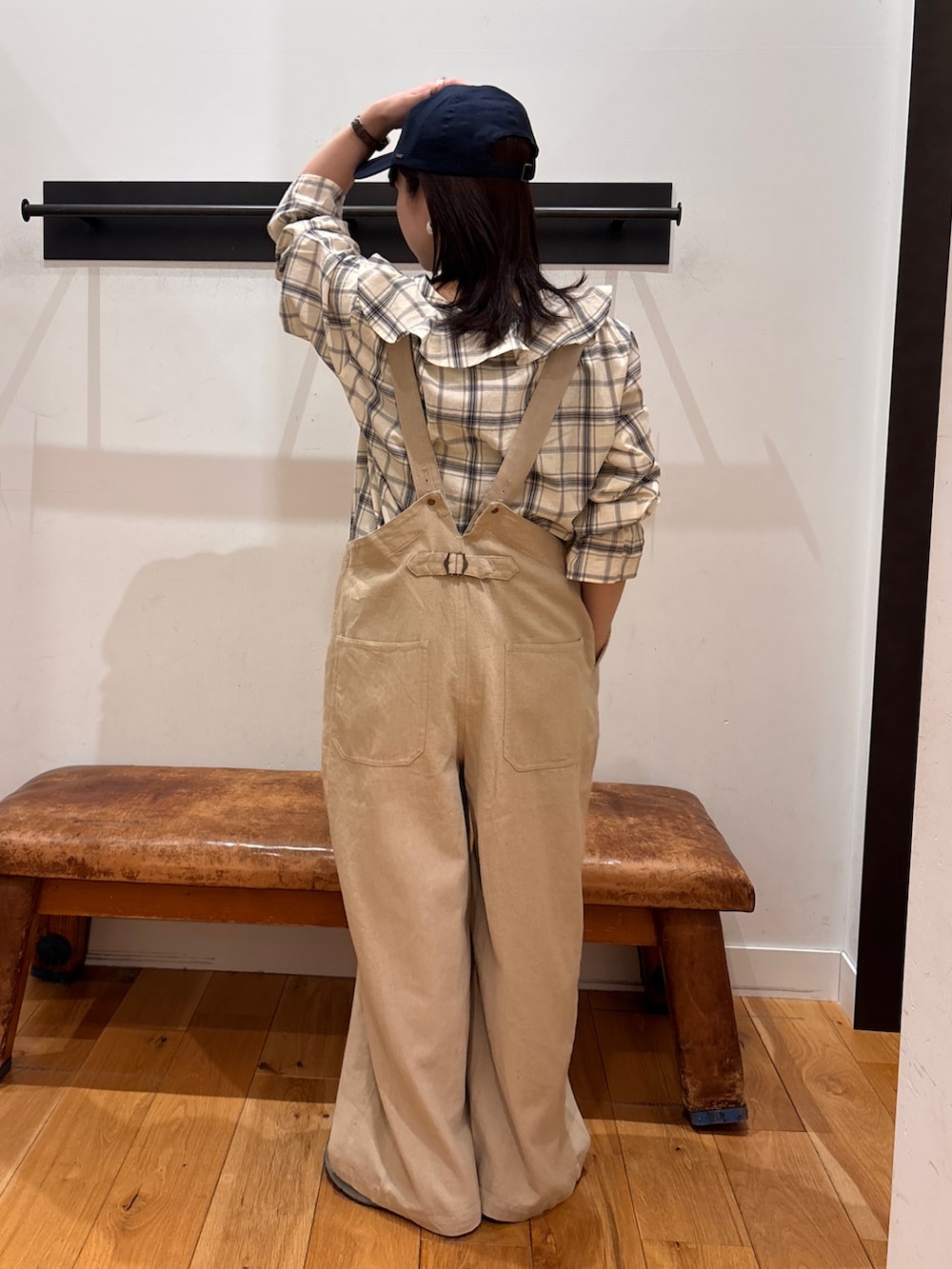 ブラック系のシャツ/ブラウス、ベージュ系のサロペット/オーバーオール、ブルー系のキャップを着用したレディースの春コーディネートの6枚目の写真