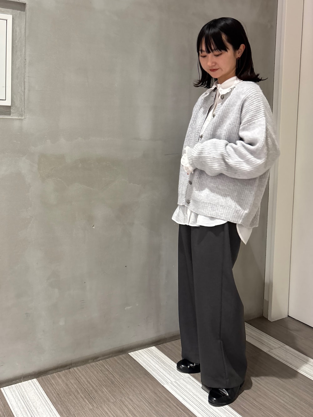 ホワイト系のシャツ/ブラウス、グレー系のカーディガン/ボレロ、グレー系のその他パンツを着用したレディースの秋コーディネートの3枚目の写真