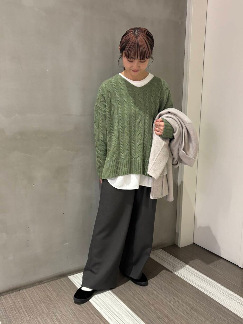 ベージュ系のその他アウター、グリーン系のニット/セーター、グレー系のその他パンツを着用したレディースの秋コーディネートの6枚目の写真