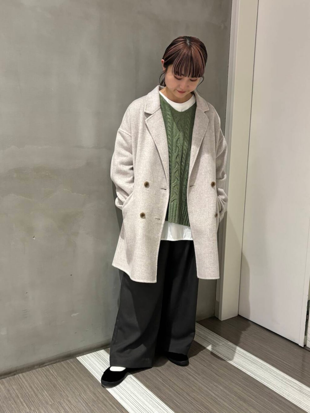 ベージュ系のその他アウター、グリーン系のニット/セーター、グレー系のその他パンツを着用したレディースの秋コーディネートの4枚目の写真