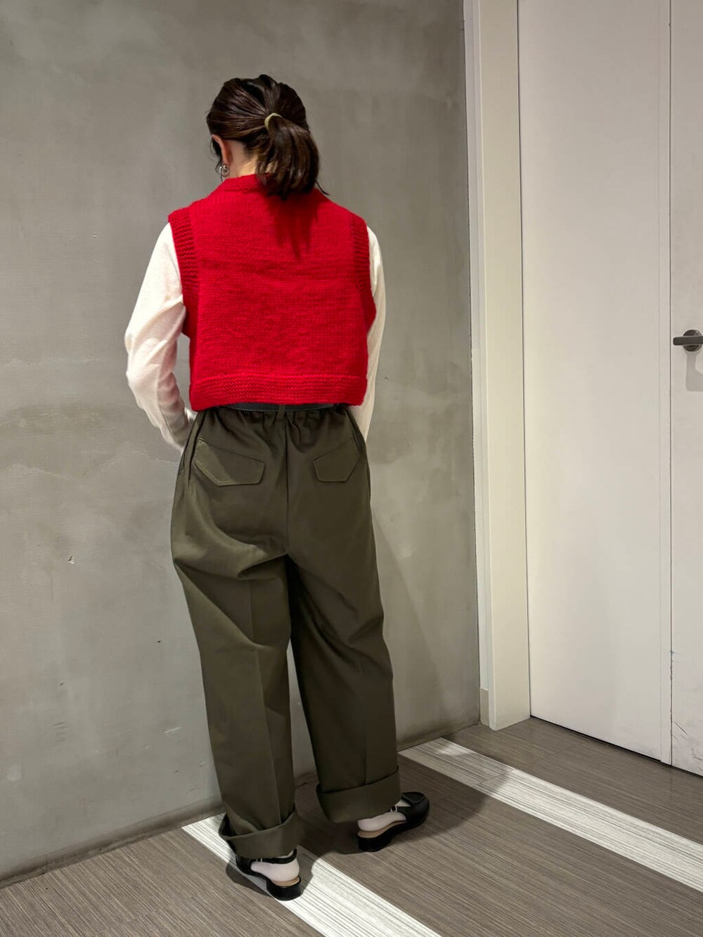 ブラック系のサンダル、ホワイト系のTシャツ/カットソー、グリーン系のチノパンツを着用したレディースの秋コーディネートの3枚目の写真