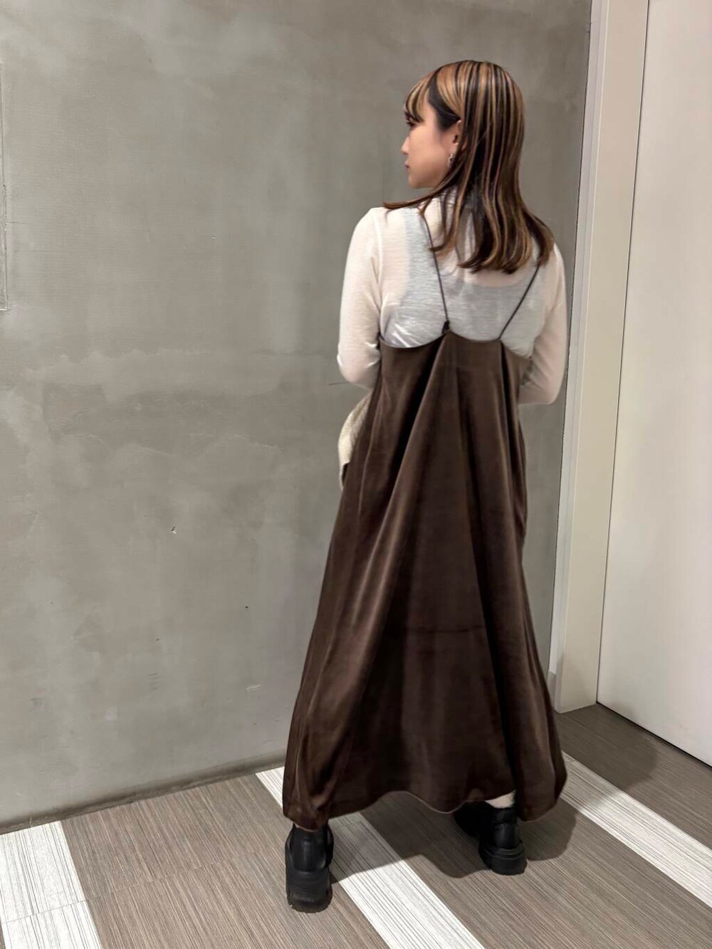 ベージュ系のカーディガン/ボレロ、ブラック系のブーツ、グリーン系のワンピースを着用したレディースの冬コーディネートの3枚目の写真