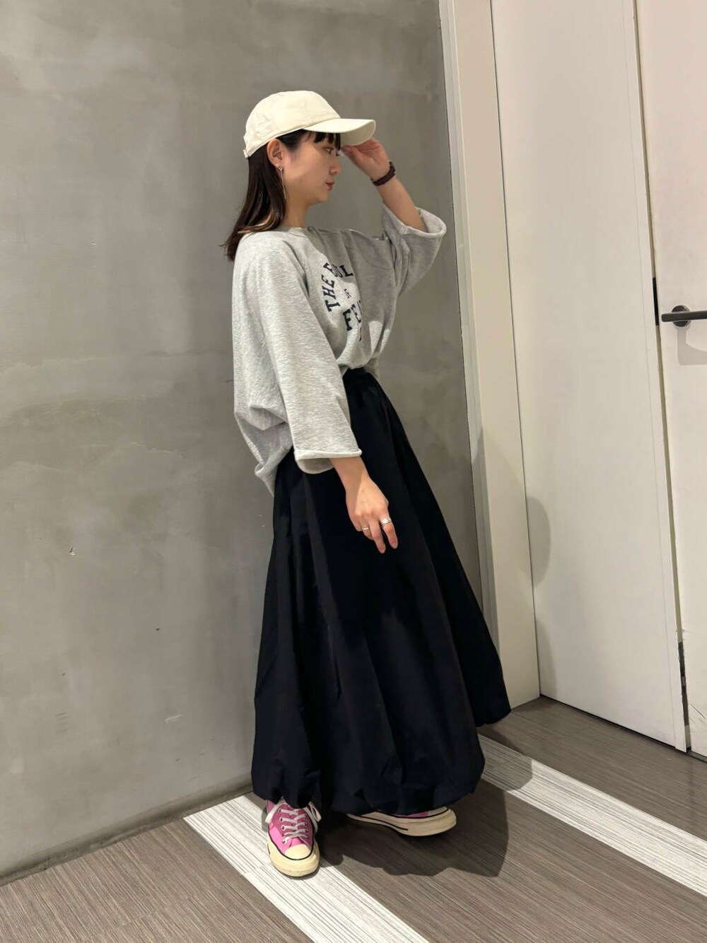 グレー系のTシャツ/カットソー、ブラック系のその他パンツ、ホワイト系のキャップを着用したレディースの秋コーディネートの6枚目の写真
