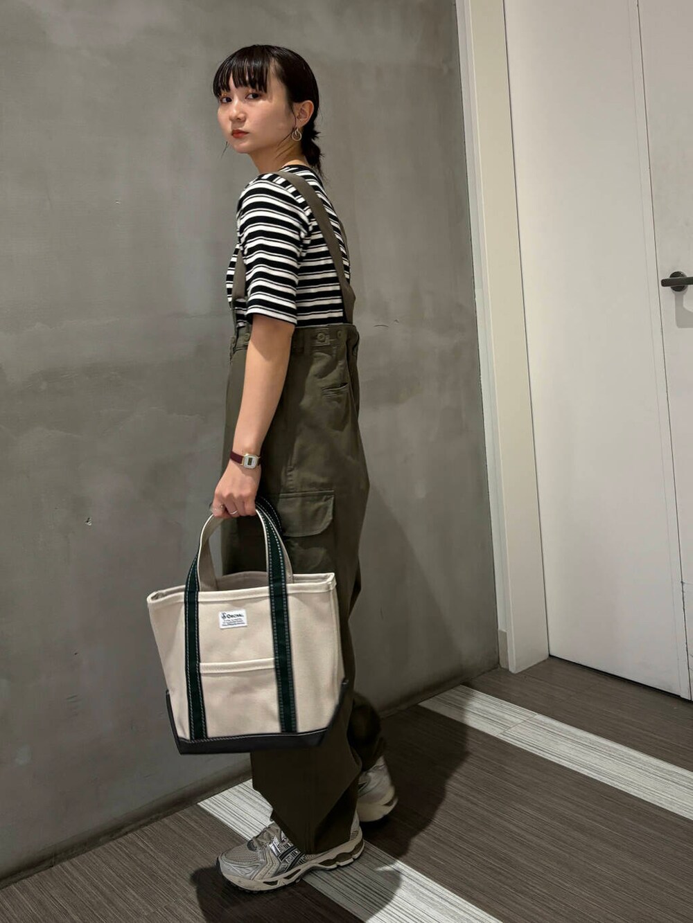 ブラック系のTシャツ/カットソー、グリーン系のカーゴパンツ、ホワイト系のトートバッグを着用したレディースの夏コーディネートの3枚目の写真