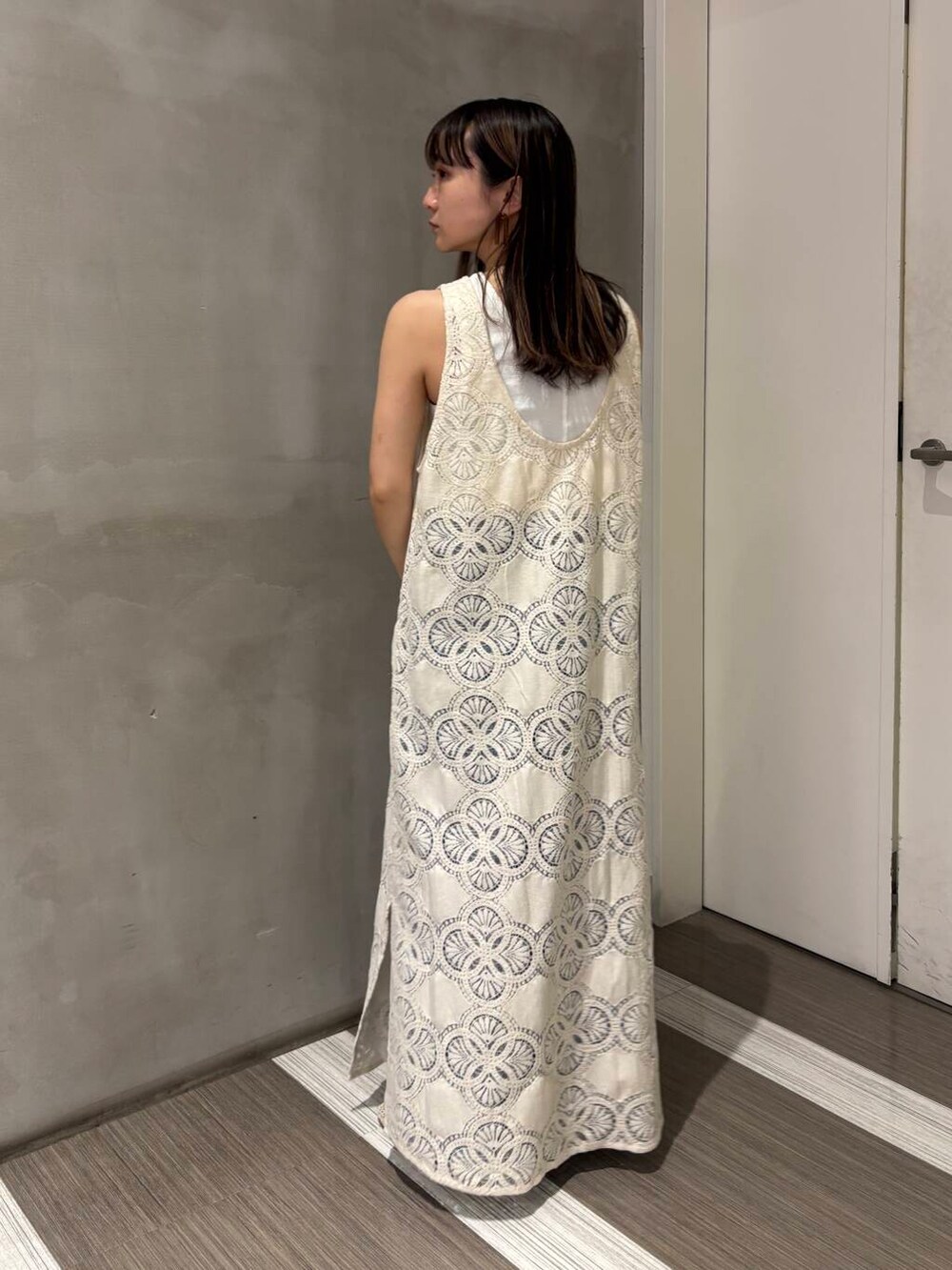 ホワイト系のタンクトップ、ブルー系のデニムパンツ、ホワイト系のバレエシューズを着用したレディースの春コーディネートの7枚目の写真