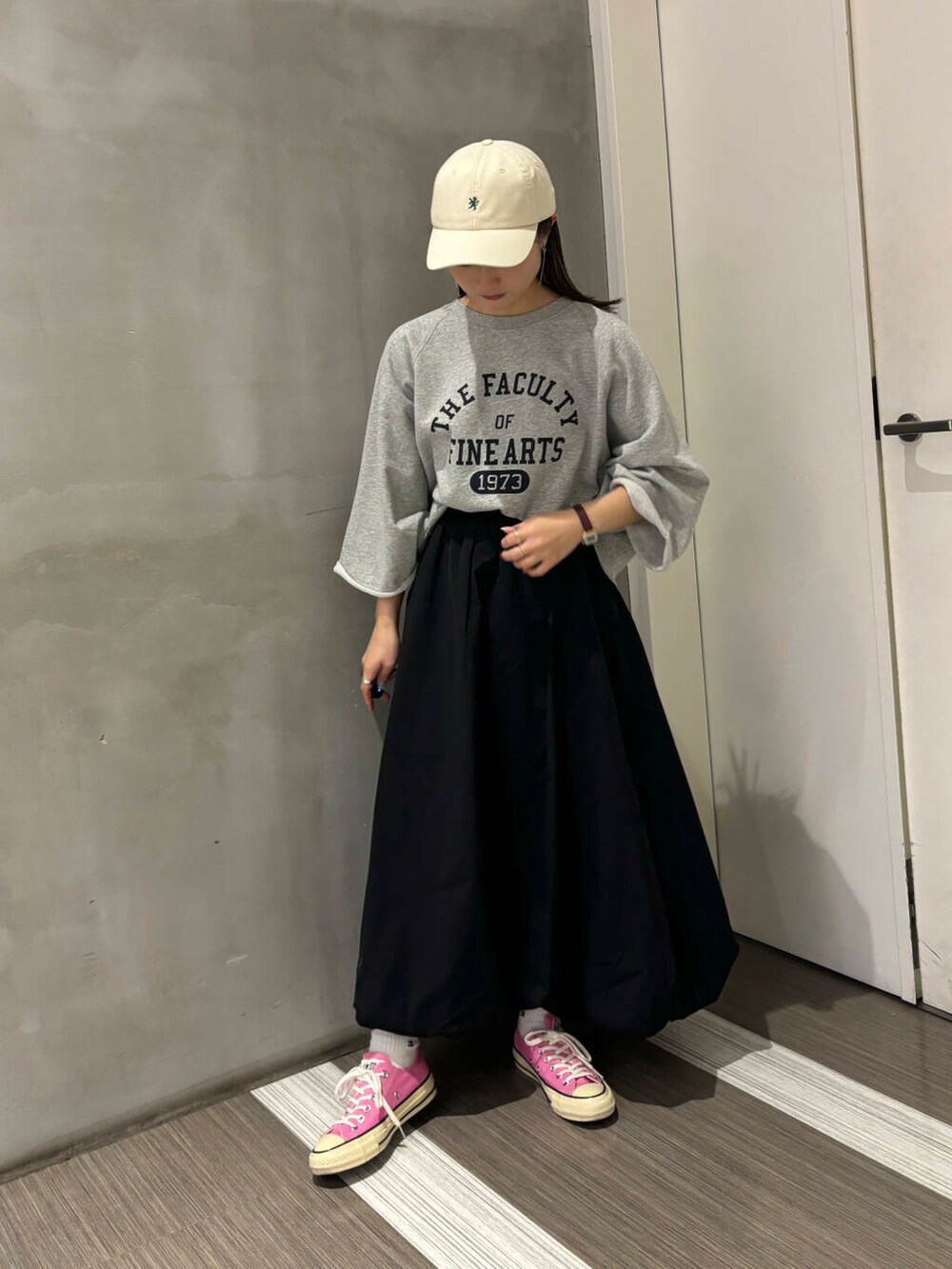 グレー系のTシャツ/カットソー、ブラック系のその他パンツ、ホワイト系のキャップを着用したレディースの秋コーディネートの7枚目の写真