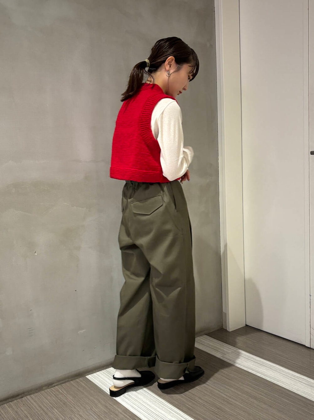 ブラック系のサンダル、ホワイト系のTシャツ/カットソー、グリーン系のチノパンツを着用したレディースの秋コーディネートの5枚目の写真