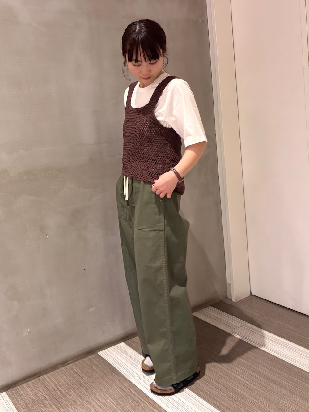 グリーン系のその他パンツ、ブラウン系のタンクトップ、ホワイト系のTシャツ/カットソーを着用したレディースの春コーディネートの6枚目の写真