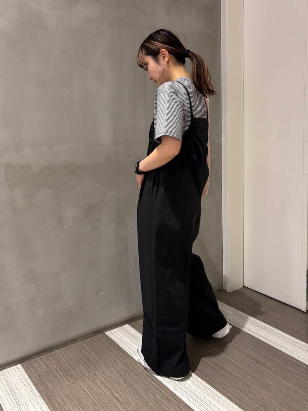 シルバー系のスニーカー、ブラック系のサロペット/オーバーオール、ピンク系のエコバッグ/サブバッグを着用したレディースの春コーディネートの3枚目の写真