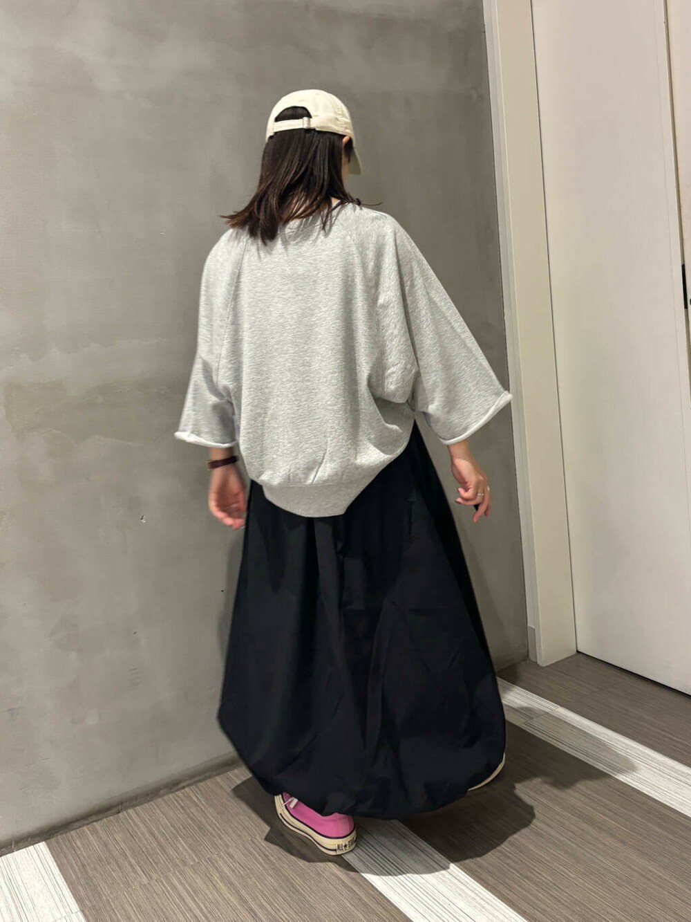 グレー系のTシャツ/カットソー、ブラック系のその他パンツ、ホワイト系のキャップを着用したレディースの秋コーディネートの3枚目の写真