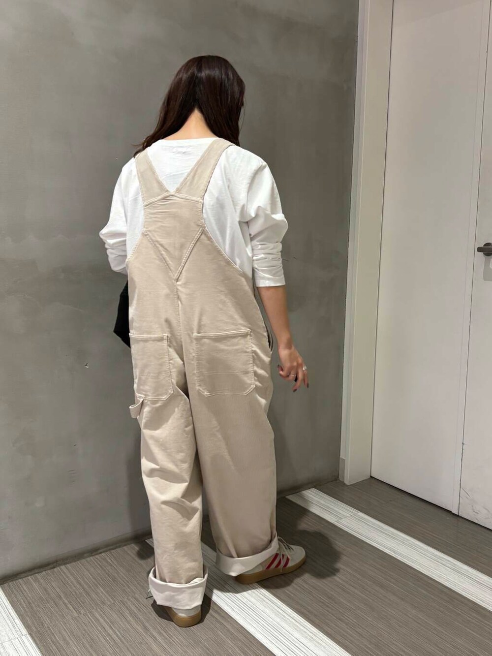 ブラック系のカーディガン/ボレロ、ホワイト系のサロペット/オーバーオール、ホワイト系のTシャツ/カットソーを着用したレディースの秋コーディネートの6枚目の写真