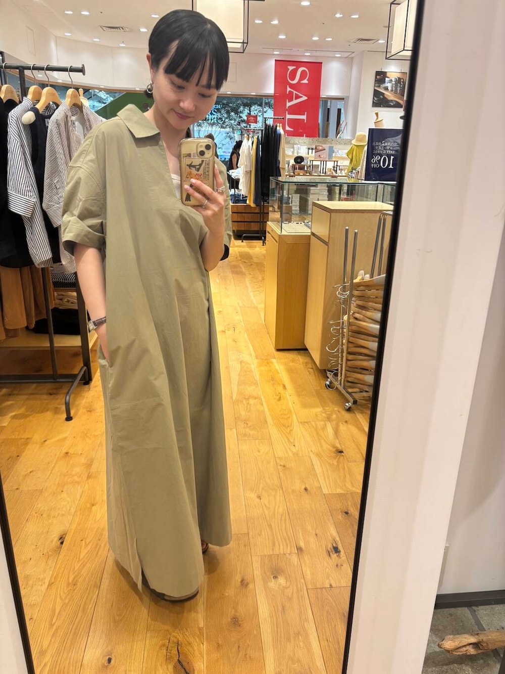 グレー系のサンダル、ベージュ系のワンピースを着用したレディースの夏コーディネートの2枚目の写真