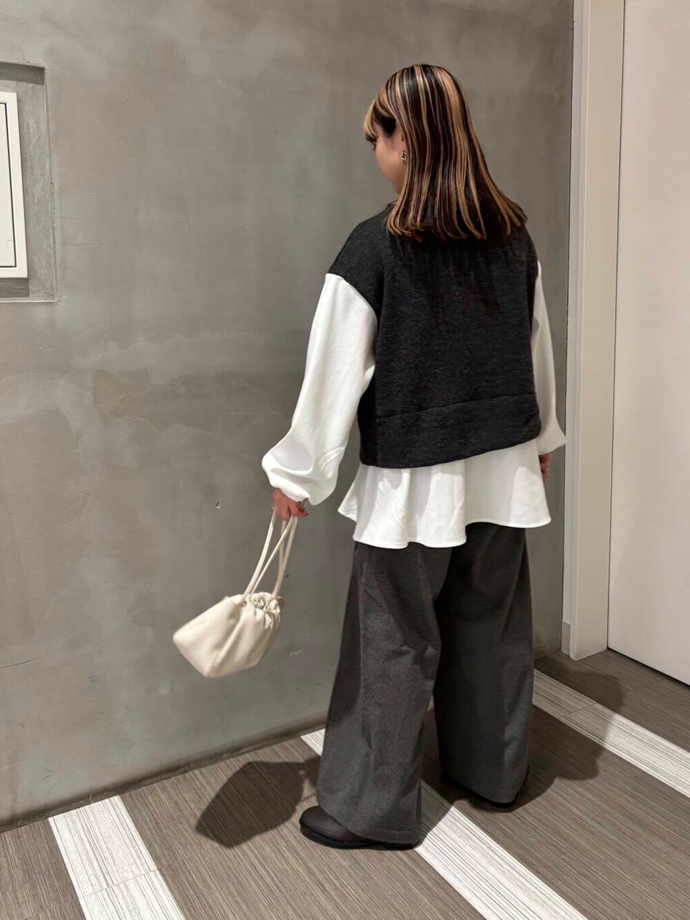 グレー系のブーツ、グレー系のその他パンツ、グレー系のTシャツ/カットソーを着用したレディースの冬コーディネートの3枚目の写真