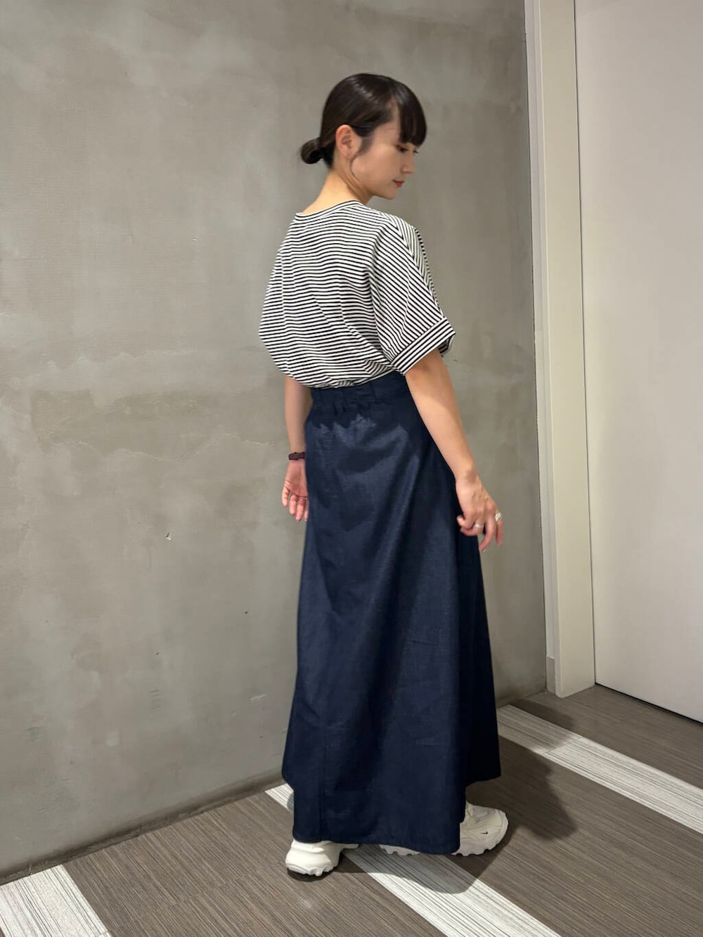 ホワイト系のスニーカー、ホワイト系のTシャツ/カットソー、ブルー系のスカートを着用したレディースの夏コーディネートの3枚目の写真