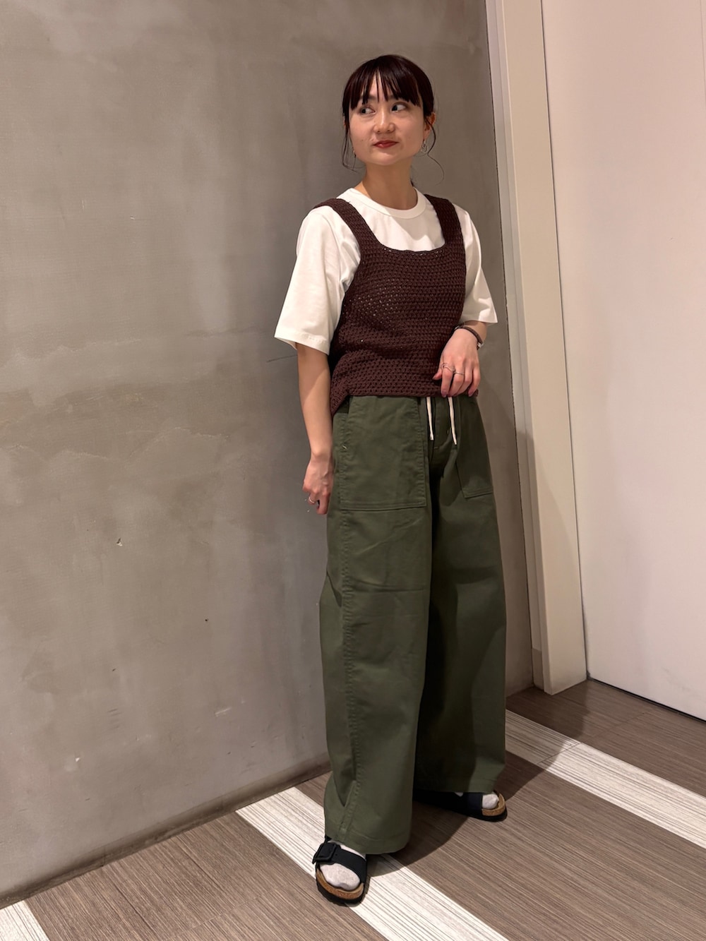 グリーン系のその他パンツ、ブラウン系のタンクトップ、ホワイト系のTシャツ/カットソーを着用したレディースの春コーディネートの7枚目の写真