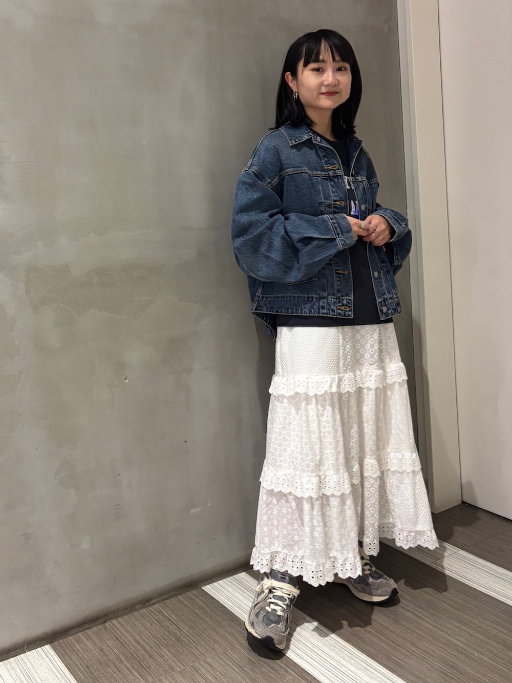 ブルー系のデニムジャケット、グレー系のTシャツ/カットソー、ホワイト系のスカートを着用したレディースの秋コーディネートの3枚目の写真