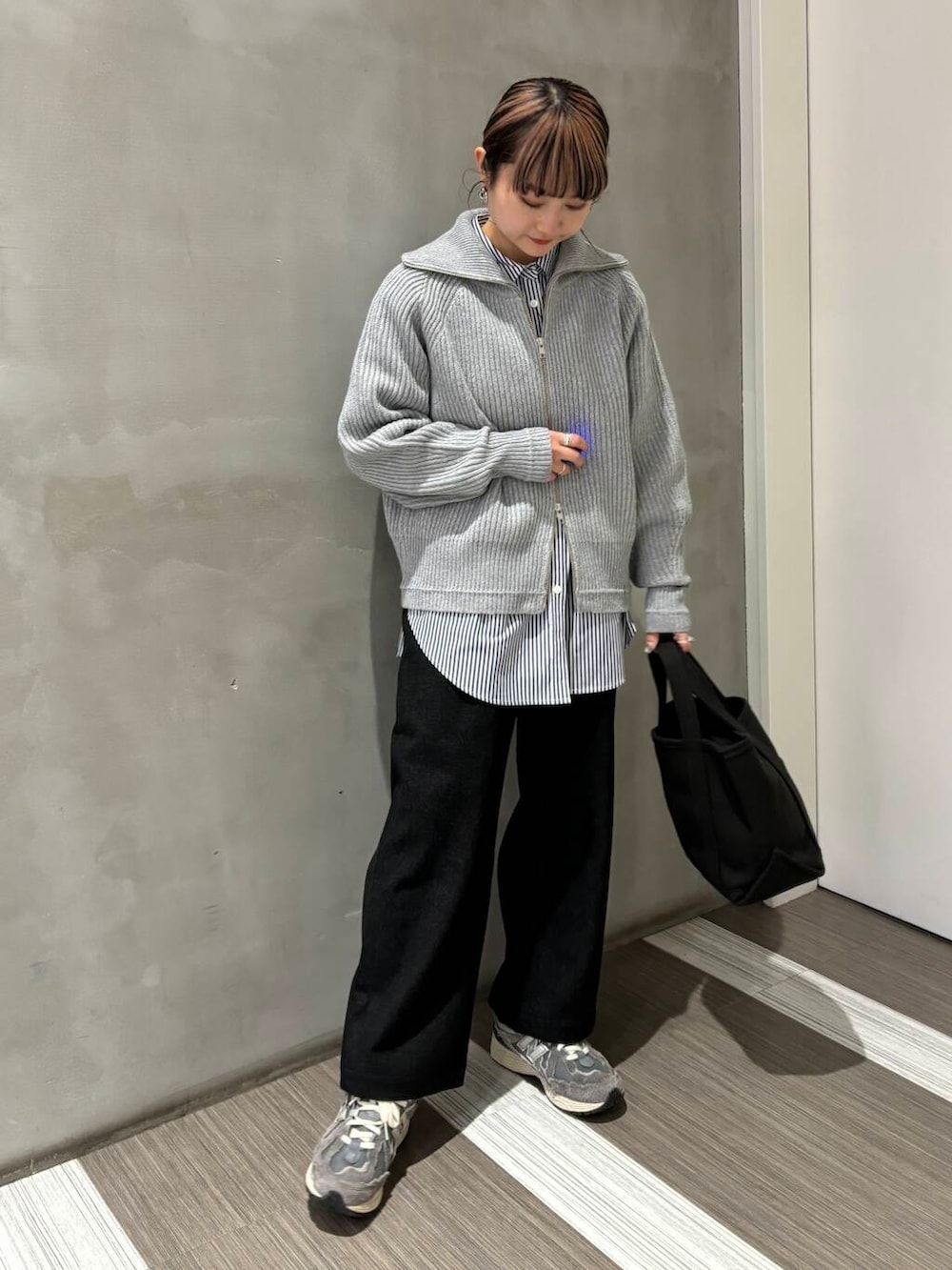 ブルー系のシャツ/ブラウス、グレー系のトートバッグ、グレー系のカーディガン/ボレロを着用したレディースの秋コーディネートの3枚目の写真