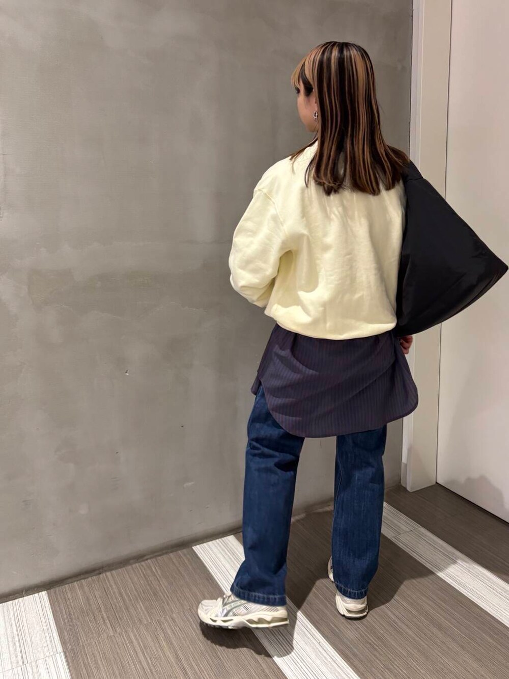 ブルー系のTシャツ/カットソー、ブルー系のデニムパンツ、ブラック系のトートバッグを着用したレディースの冬コーディネートの4枚目の写真