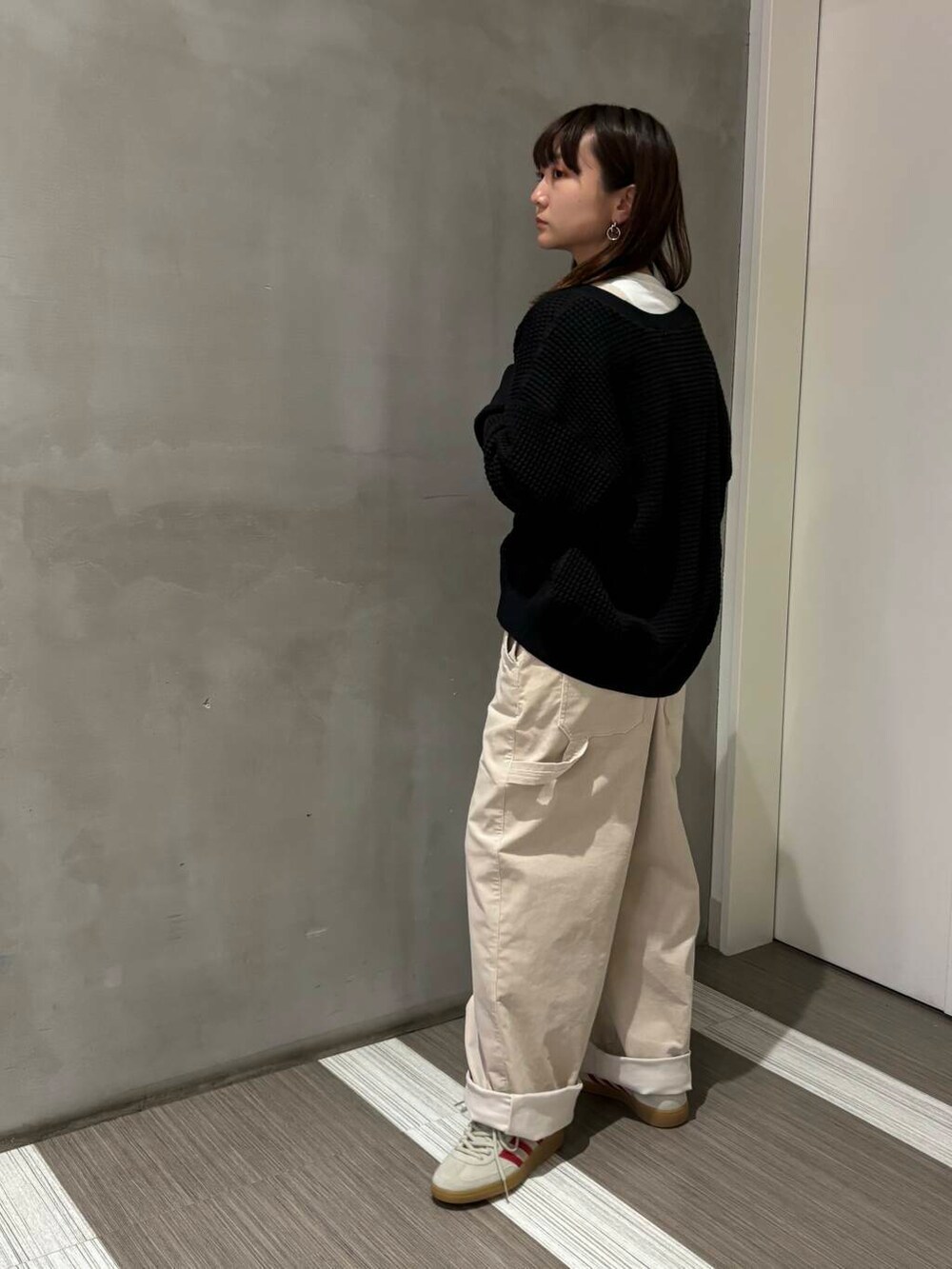 ブラック系のカーディガン/ボレロ、ホワイト系のサロペット/オーバーオール、ホワイト系のTシャツ/カットソーを着用したレディースの秋コーディネートの4枚目の写真