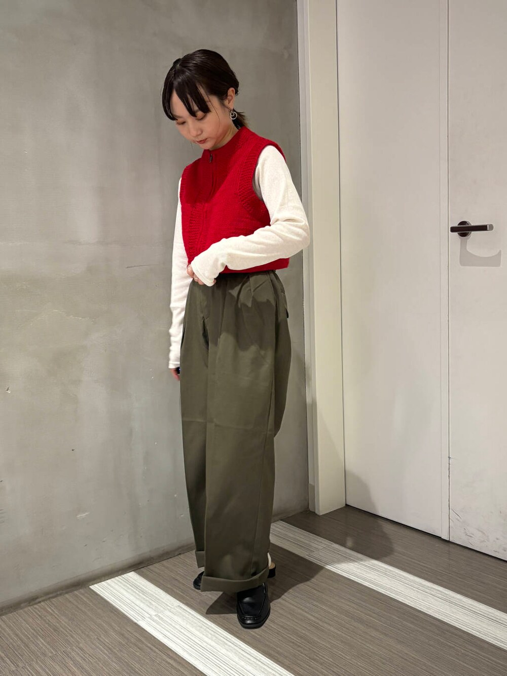 ブラック系のサンダル、ホワイト系のTシャツ/カットソー、グリーン系のチノパンツを着用したレディースの秋コーディネートの2枚目の写真