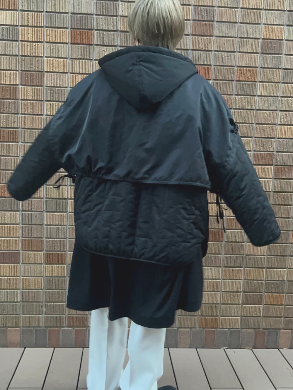 ブラック系のブルゾン、ブラック系のベスト、ホワイト系のパンツを着用したメンズの春コーディネートの2枚目の写真