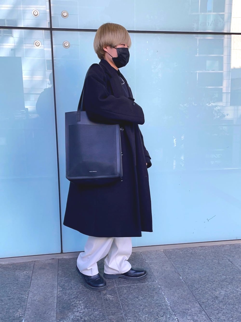 ホワイト系のパンツ、ブラック系のTシャツ/カットソー、ブラック系のトートバッグを着用したメンズの冬コーディネートの2枚目の写真