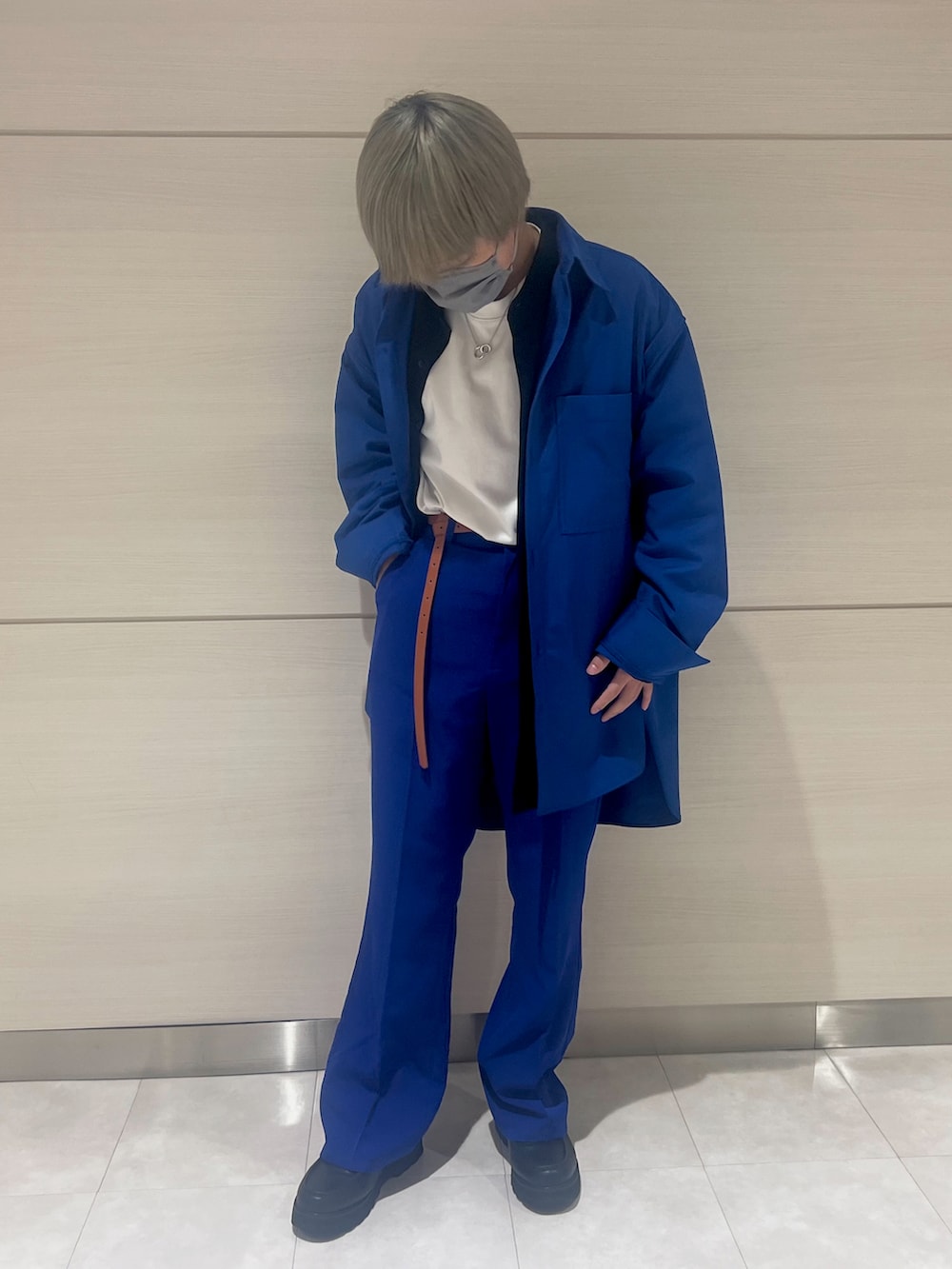 ブルー系のスラックス、ブラック系のローファー、ブラック系のブルゾンを着用したメンズの春コーディネートの2枚目の写真