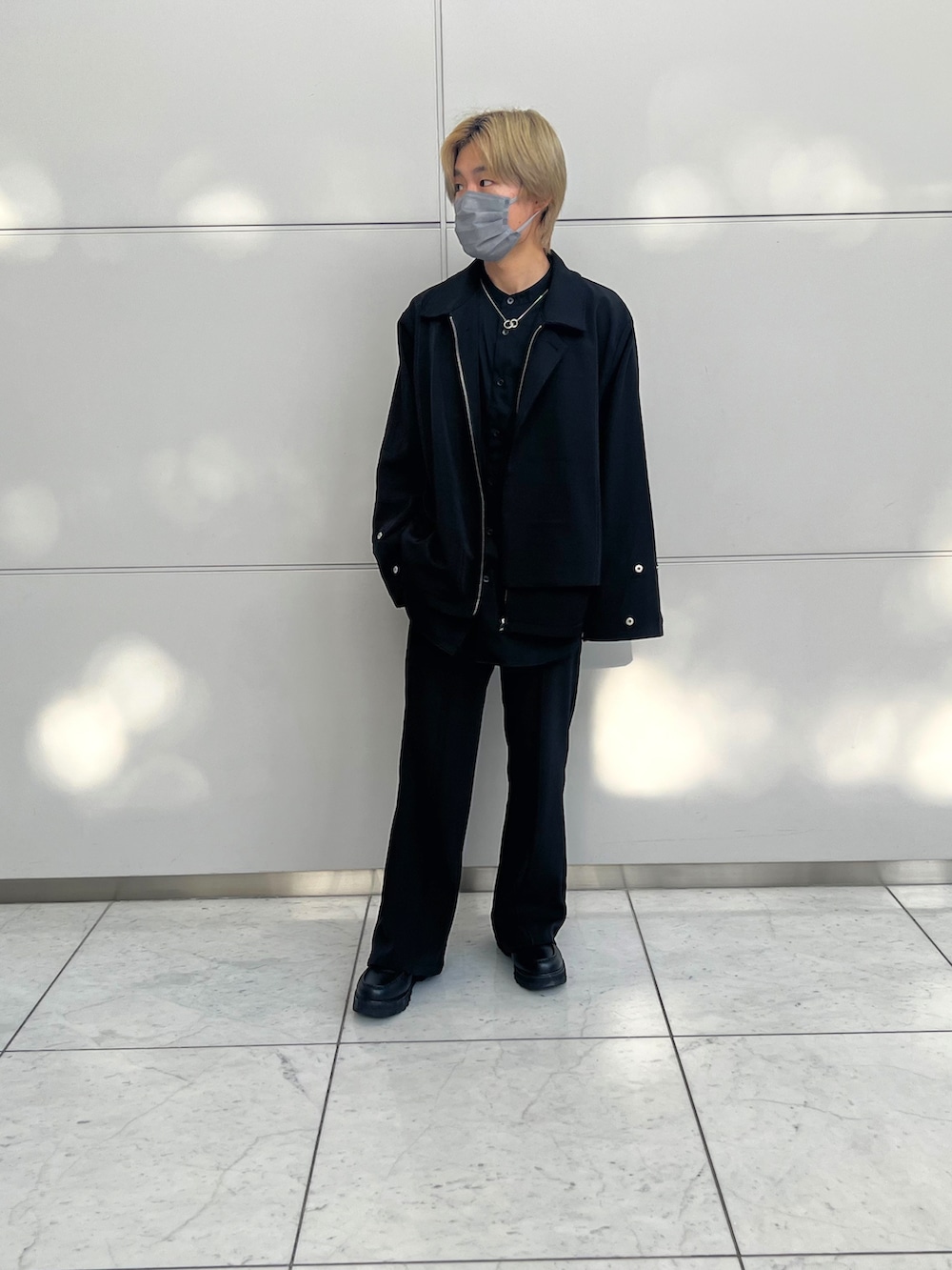 ブラック系のスラックス、ブラック系のブルゾン、ブラック系のローファーを着用したメンズの春コーディネートの2枚目の写真