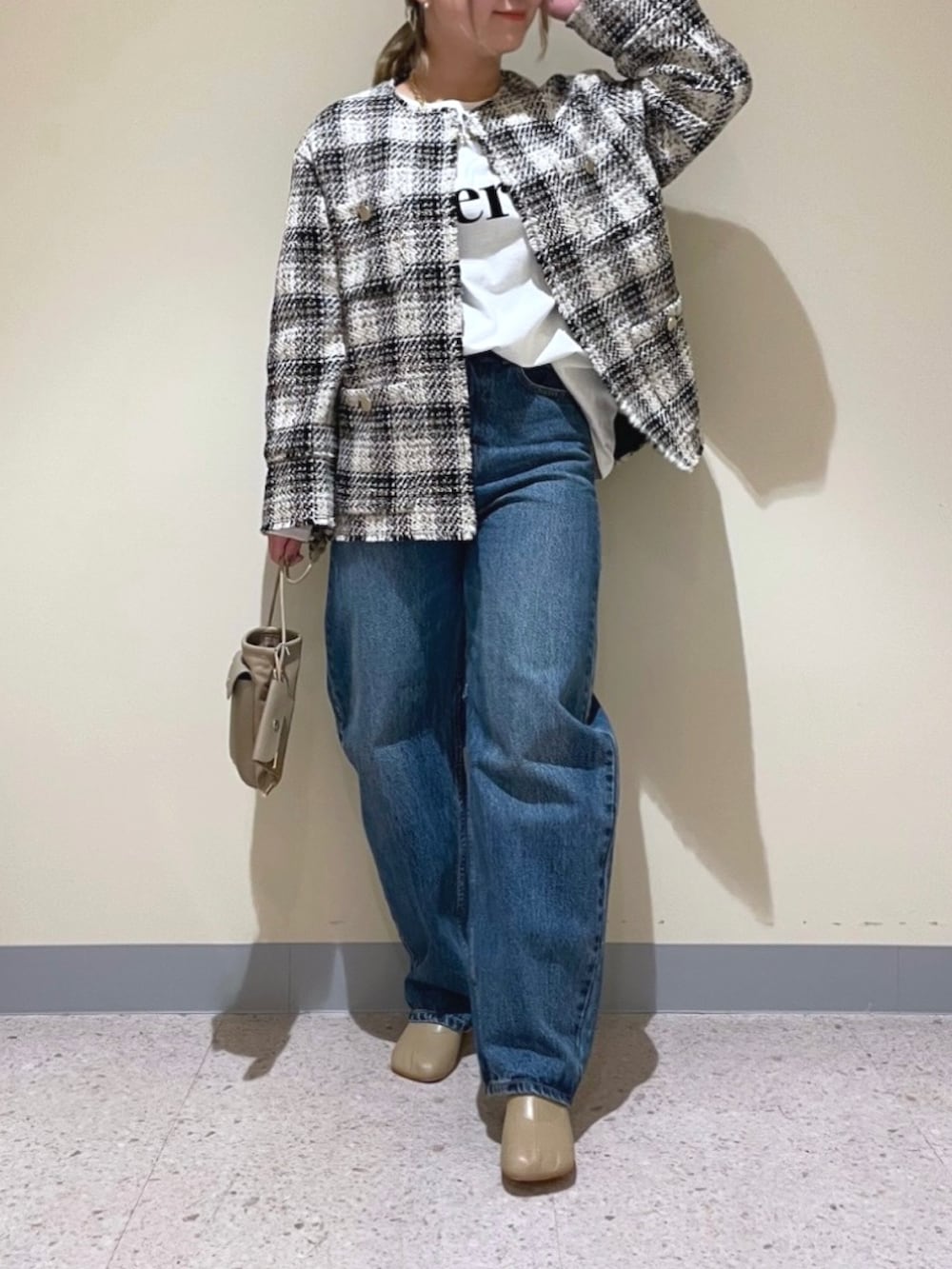 ブラック系のノーカラージャケット、ブルー系のデニムパンツ、ホワイト系のTシャツ/カットソーを着用したレディースの冬コーディネートの2枚目の写真
