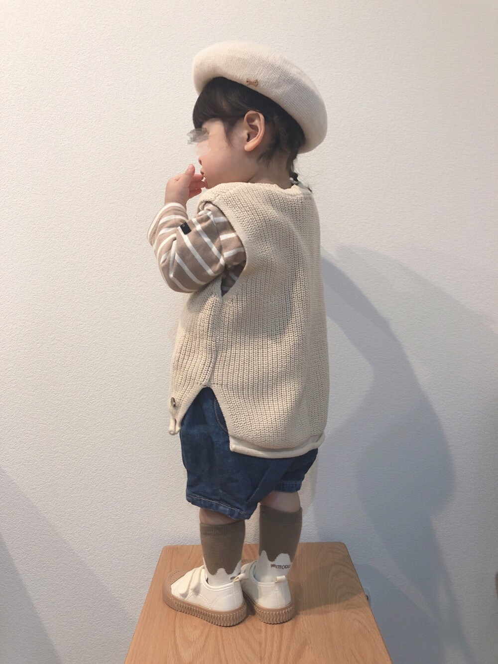 ベージュ系のTシャツ/カットソー、ベージュ系のベスト、ブルー系のデニムパンツを着用したキッズの春コーディネートの4枚目の写真