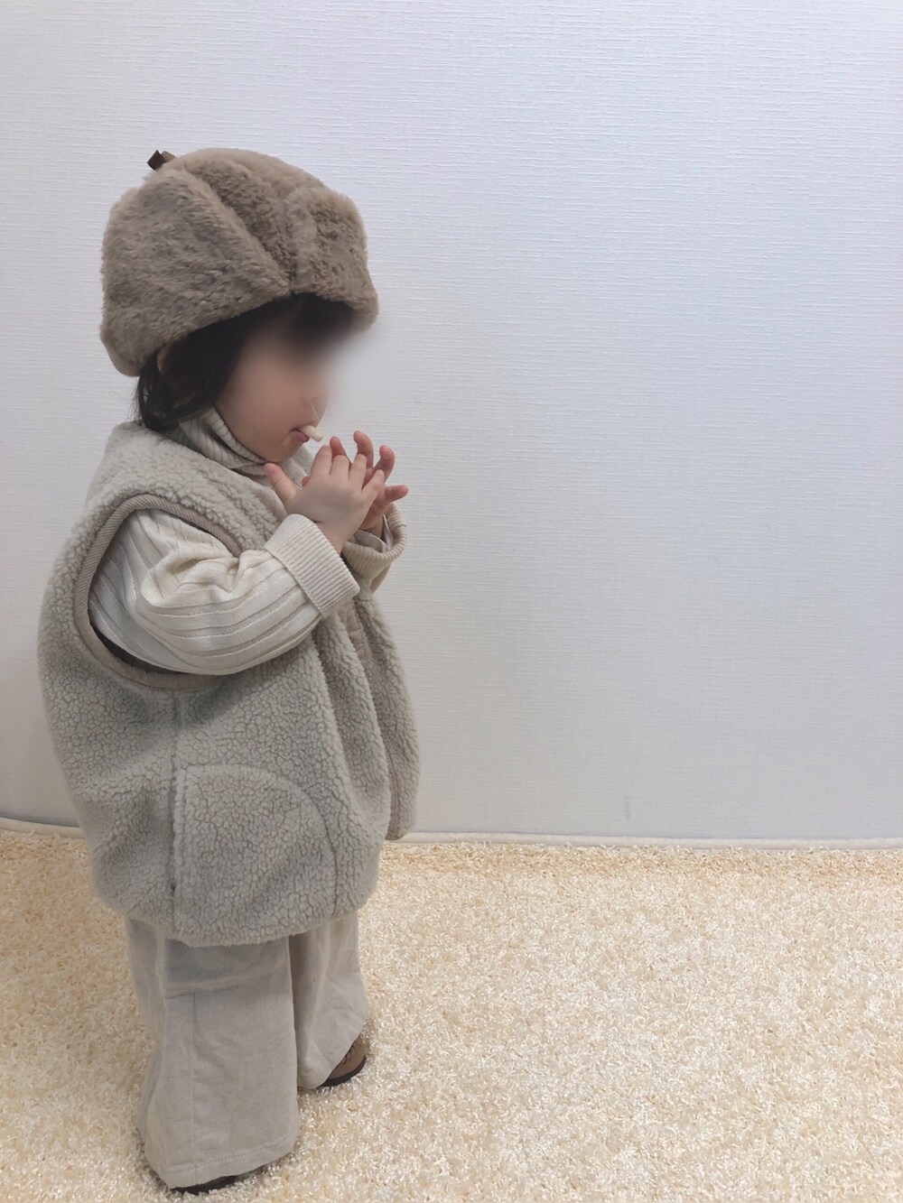 ホワイト系のニット/セーター、ホワイト系のサロペット/オーバーオール、ベージュ系のベストを着用したキッズの冬コーディネートの2枚目の写真