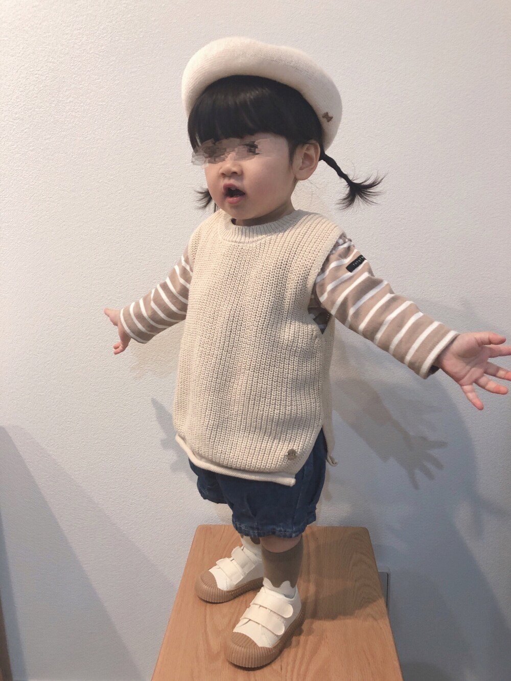 ベージュ系のTシャツ/カットソー、ベージュ系のベスト、ブルー系のデニムパンツを着用したキッズの春コーディネートの3枚目の写真