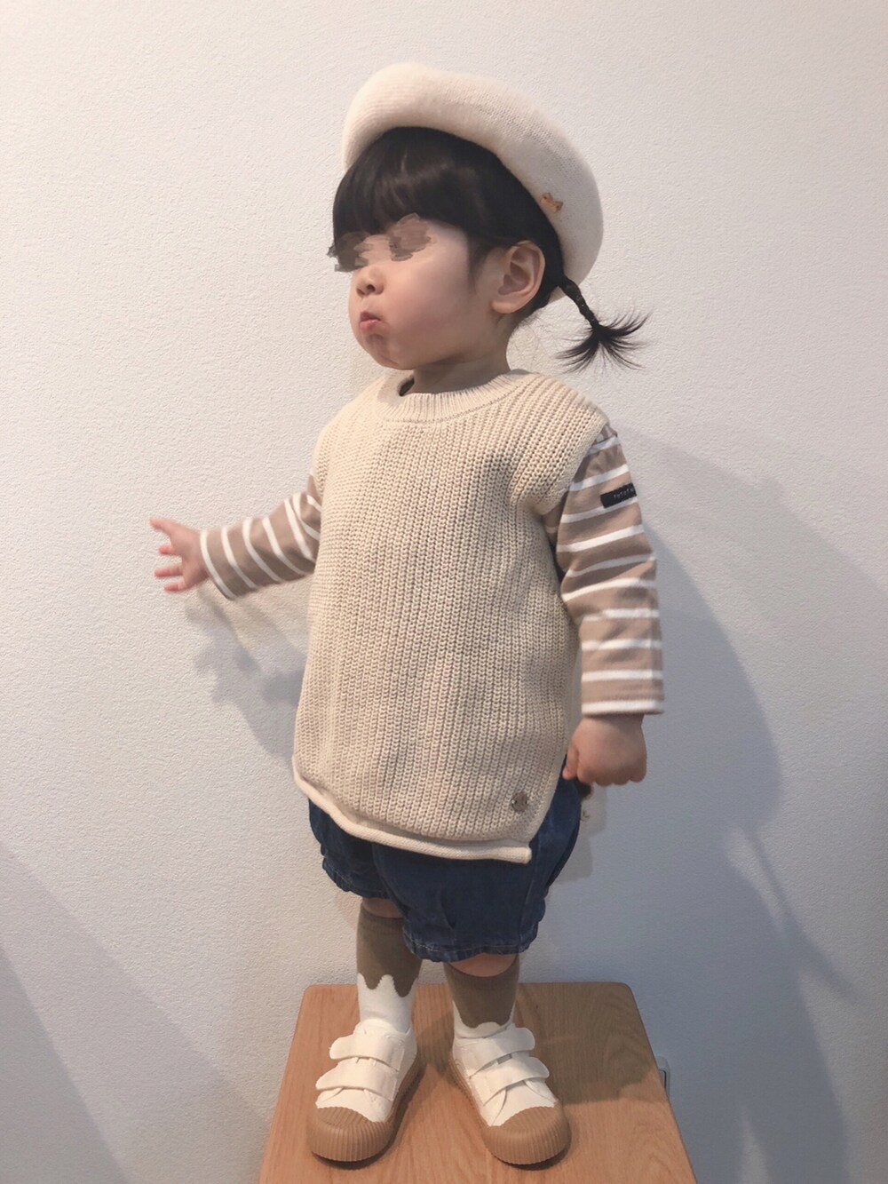 ベージュ系のTシャツ/カットソー、ベージュ系のベスト、ブルー系のデニムパンツを着用したキッズの春コーディネートの2枚目の写真