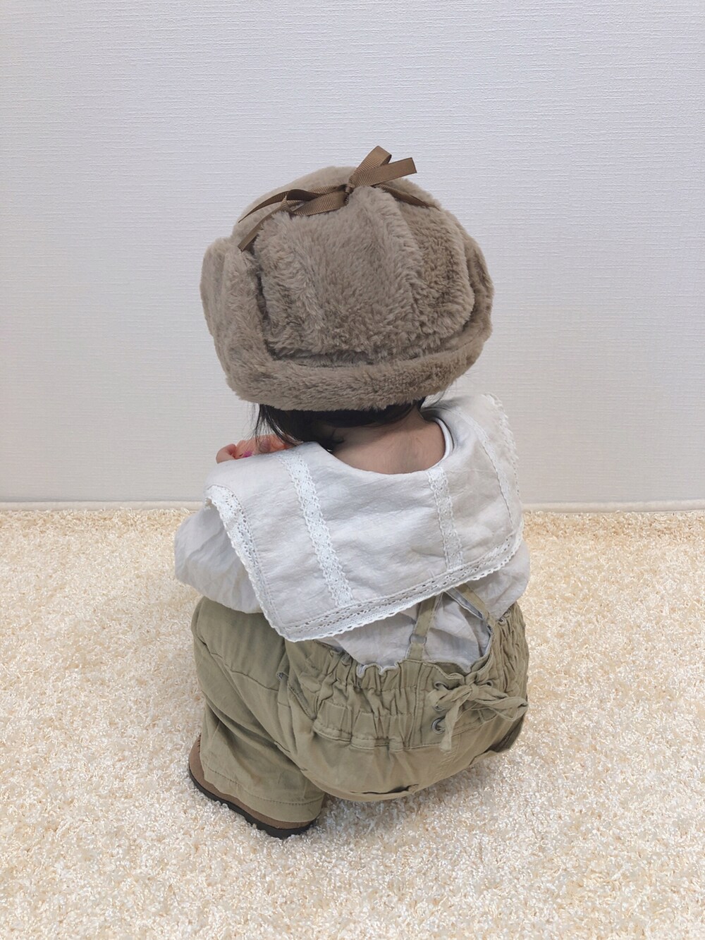 ホワイト系のシャツ/ブラウス、ベージュ系のサロペット/オーバーオール、ベージュ系のモカシン/デッキシューズを着用したキッズの冬コーディネートの4枚目の写真