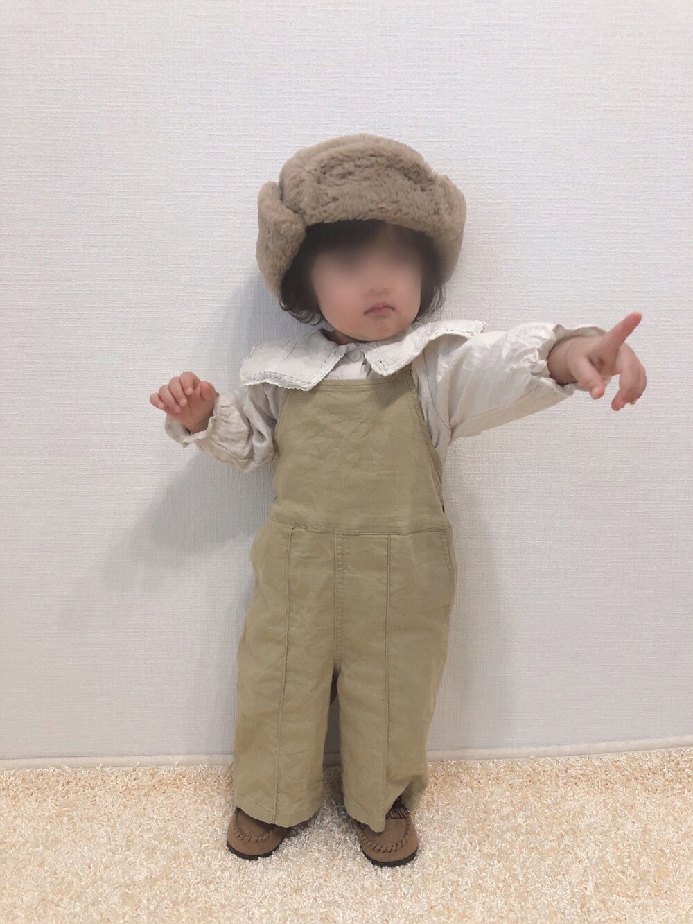 ホワイト系のシャツ/ブラウス、ベージュ系のサロペット/オーバーオール、ベージュ系のモカシン/デッキシューズを着用したキッズの冬コーディネートの3枚目の写真