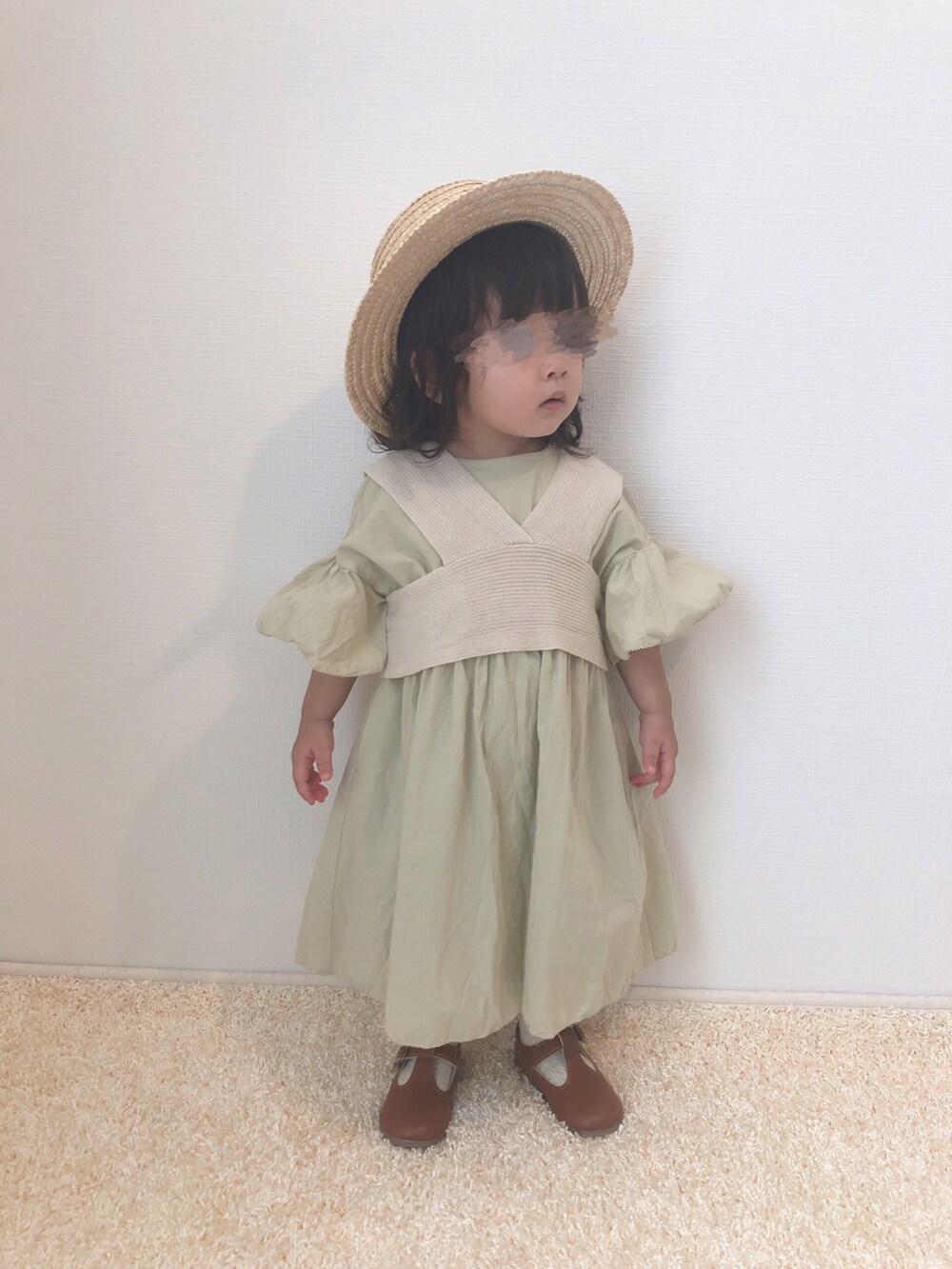グリーン系のワンピース、ブラウン系のシューズ、ベージュ系のハットを着用したキッズの夏コーディネートの2枚目の写真
