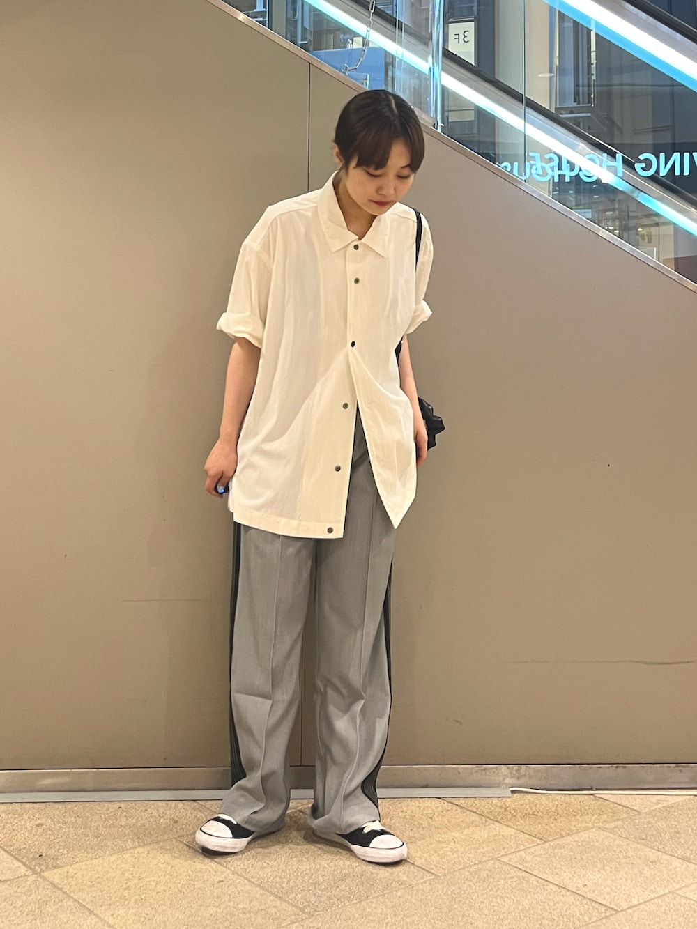 ホワイト系のシャツ/ブラウス、グレー系のパンツ、ブラック系のショルダーバッグを着用したレディースの夏コーディネートの2枚目の写真