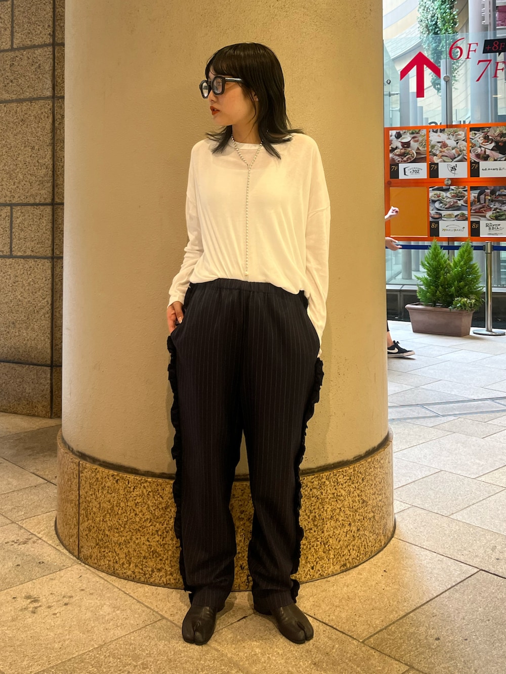 ホワイト系のTシャツ/カットソー、ブラック系のブーツを着用したレディースの秋コーディネートの2枚目の写真