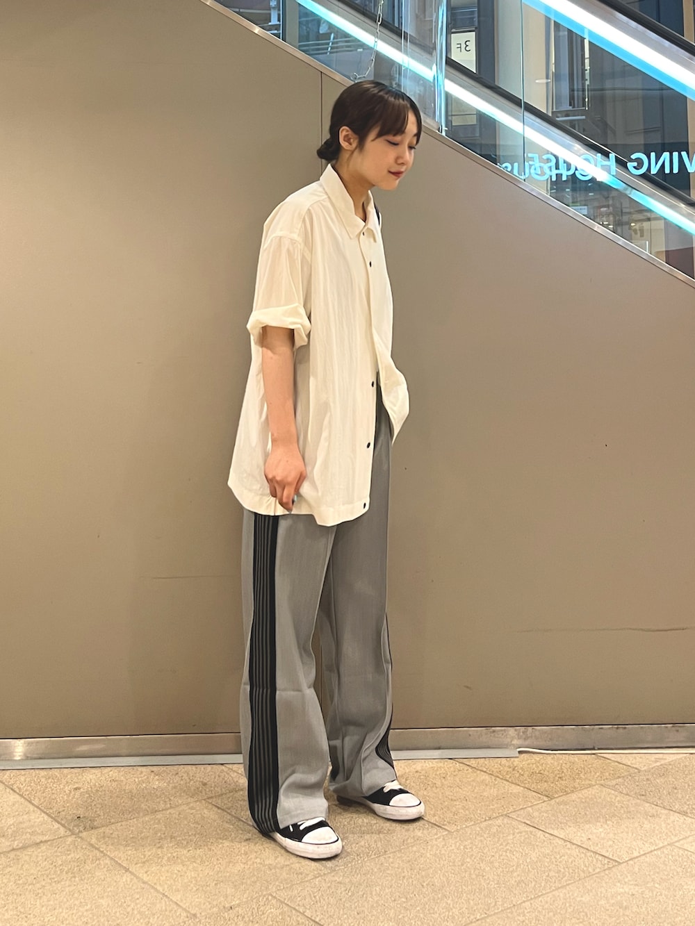 ホワイト系のシャツ/ブラウス、グレー系のパンツ、ブラック系のショルダーバッグを着用したレディースの夏コーディネートの3枚目の写真
