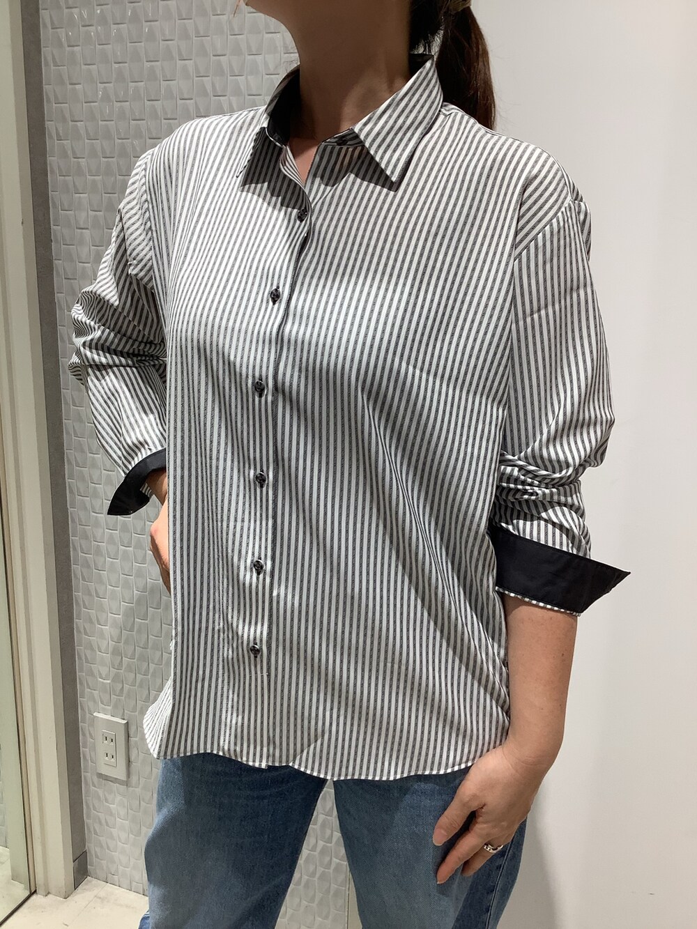 グレー系のビジネスシャツ、グレー系のベストを着用したレディースの秋コーディネートの3枚目の写真