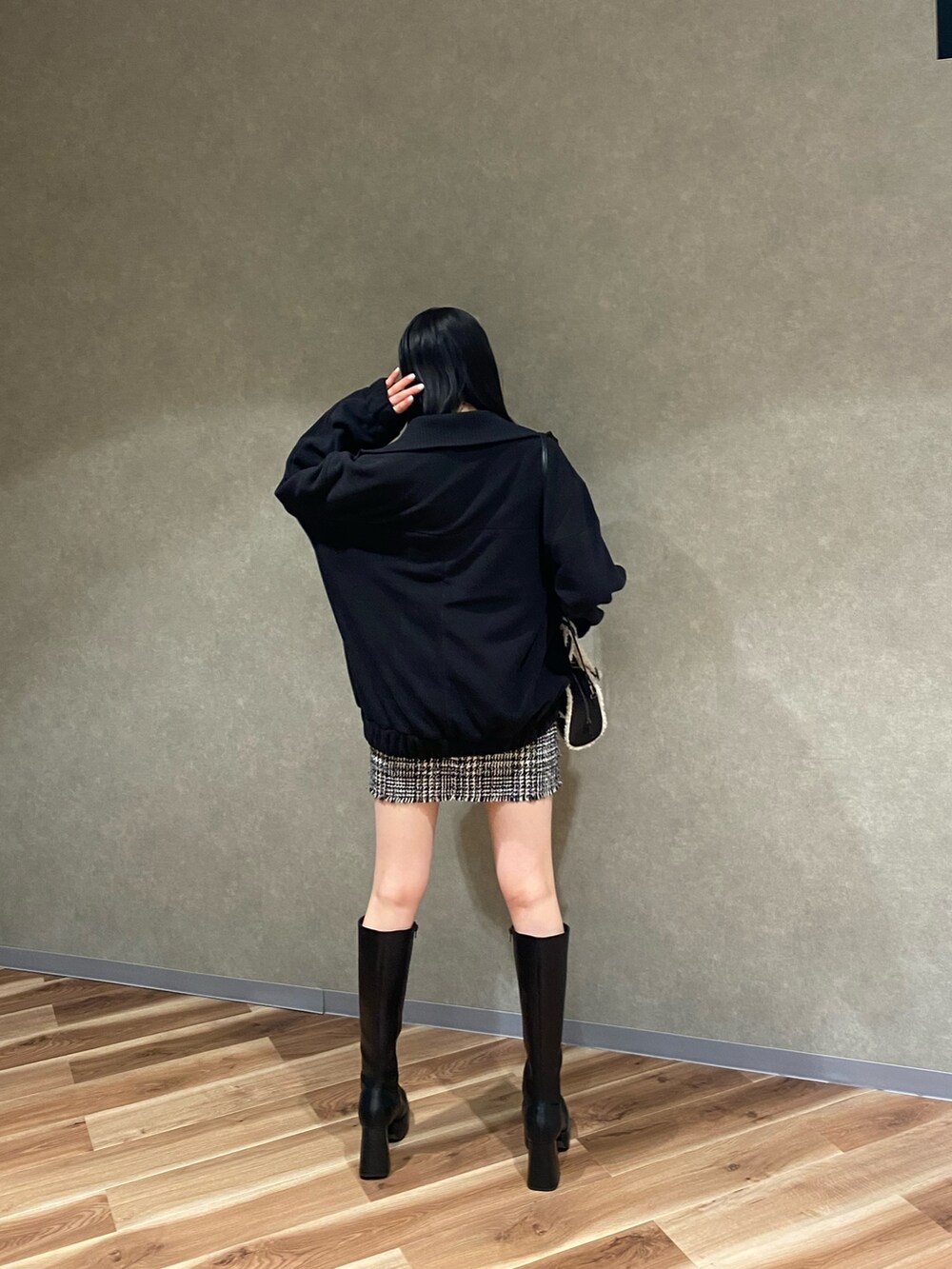 ブラック系のブルゾン、ブラック系のブーツ、ブラック系のハンドバッグを着用したレディースの秋コーディネートの3枚目の写真