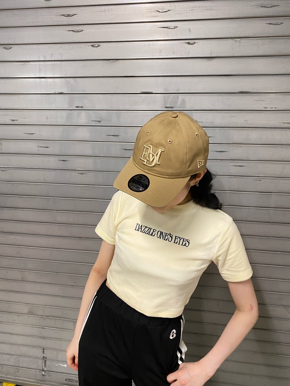 オレンジ系のTシャツ/カットソー、ブラック系のその他パンツ、ホワイト系のハンドバッグを着用したレディースの夏コーディネートの4枚目の写真