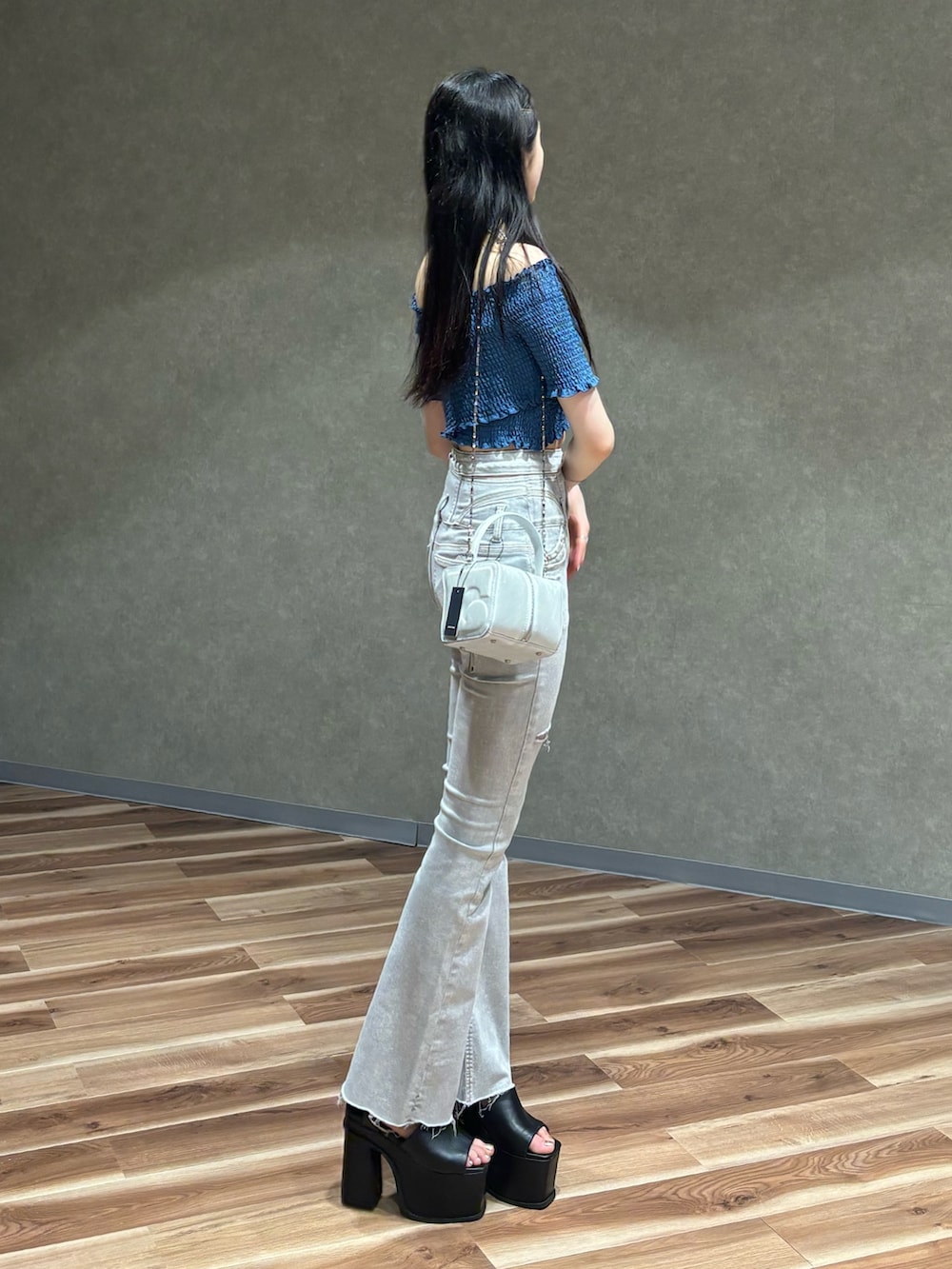 ホワイト系のデニムパンツ、ブルー系のTシャツ/カットソー、ピンク系のハンドバッグを着用したレディースの夏コーディネートの2枚目の写真