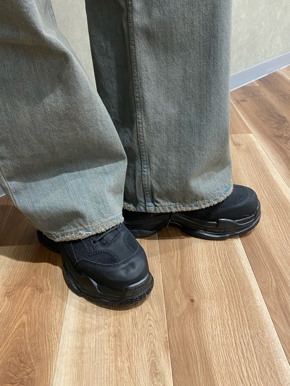 グレー系のデニムパンツ、ブラック系のスニーカー、ブラック系のハンドバッグを着用したレディースの冬コーディネートの8枚目の写真