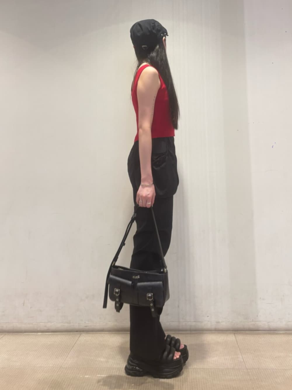 ブラック系のハンドバッグ、ブラック系のその他パンツ、レッド系のTシャツ/カットソーを着用したレディースの夏コーディネートの2枚目の写真