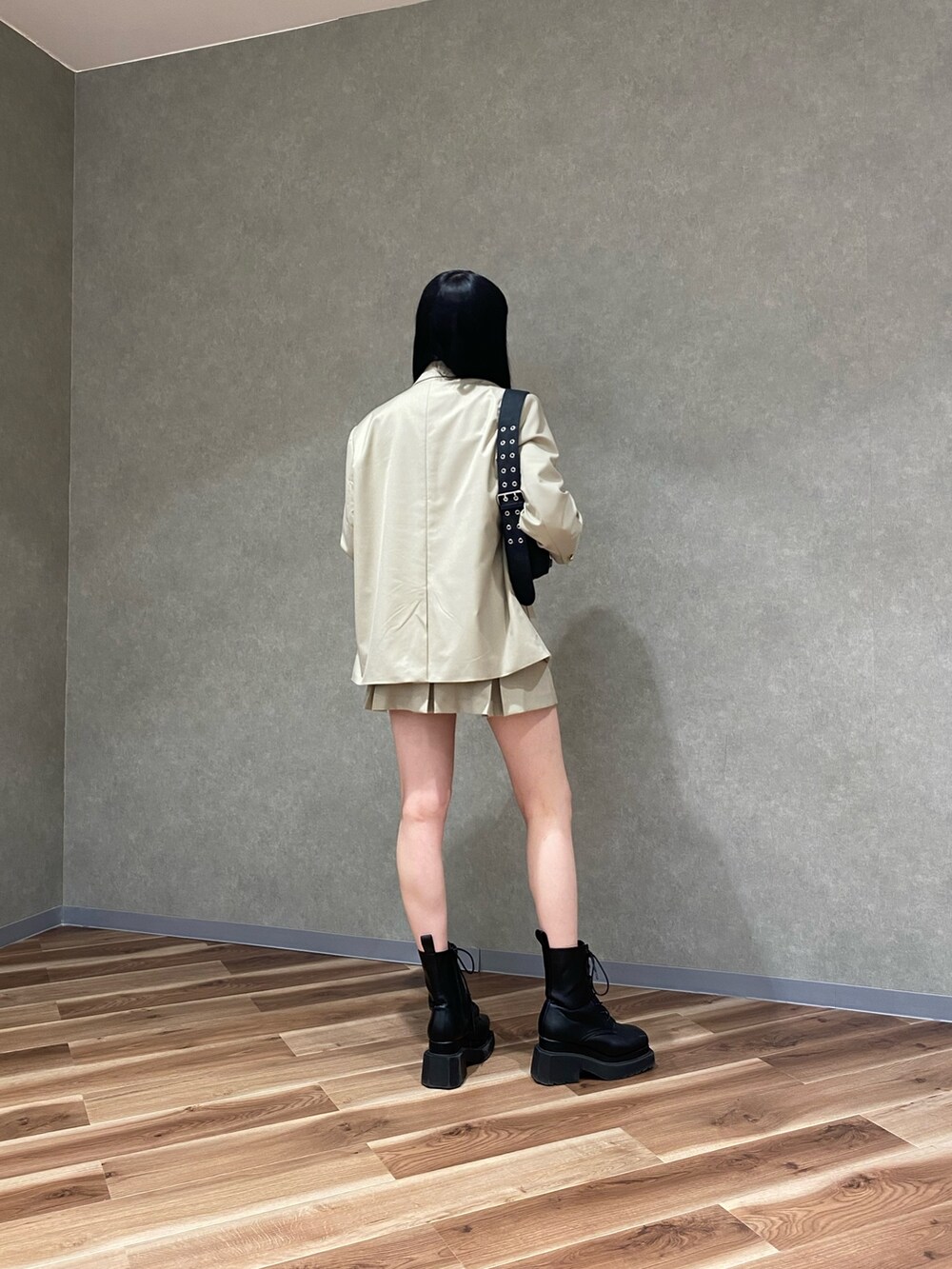 ベージュ系のテーラードジャケット、ブラック系のブーツ、ベージュ系のスカートを着用したレディースの冬コーディネートの3枚目の写真