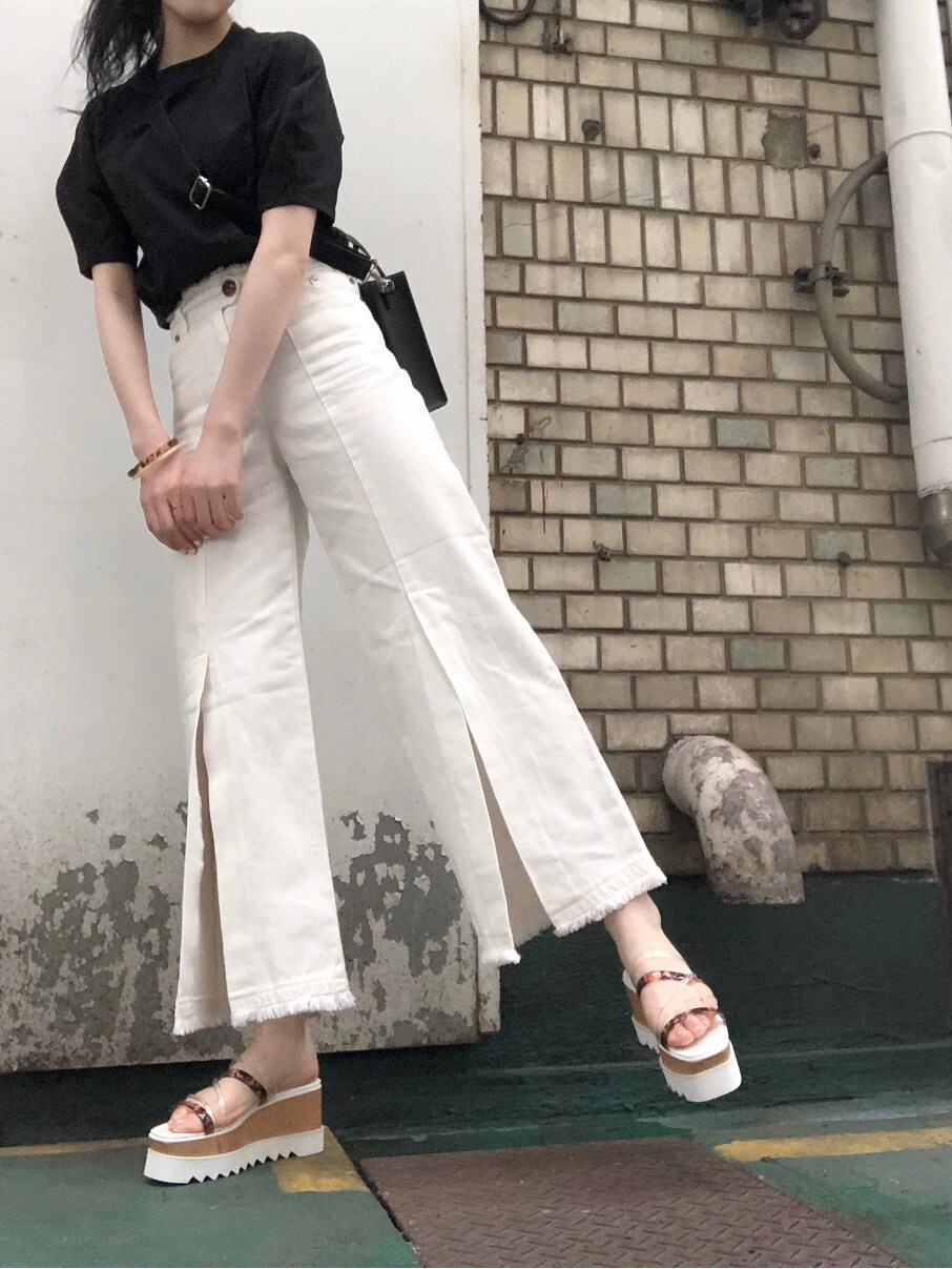 ホワイト系のその他パンツ、ブラック系のTシャツ/カットソー、ブラック系のショルダーバッグを着用したレディースの春コーディネートの4枚目の写真