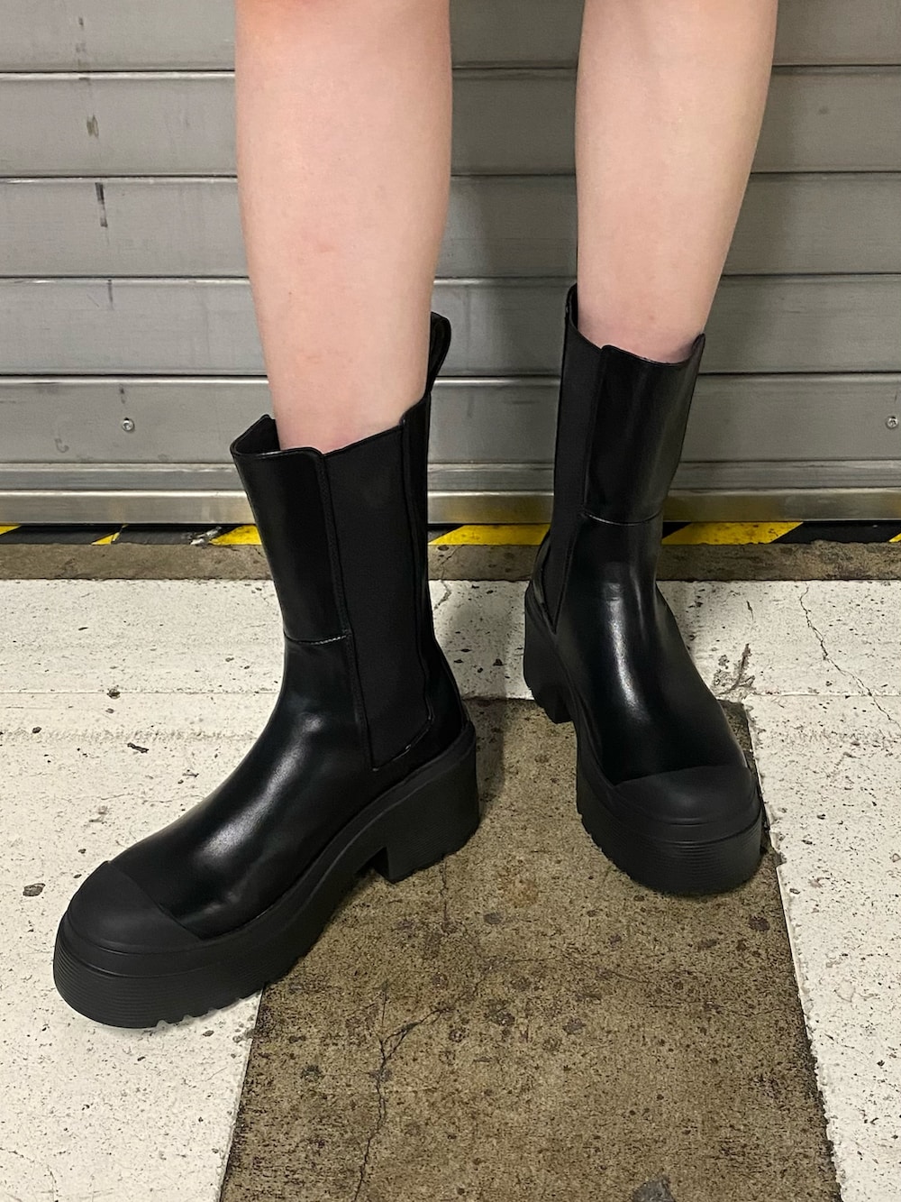 ブラック系のブーツ、ブラウン系のワンピース、ベージュ系のニット/セーターを着用したレディースの夏コーディネートの5枚目の写真