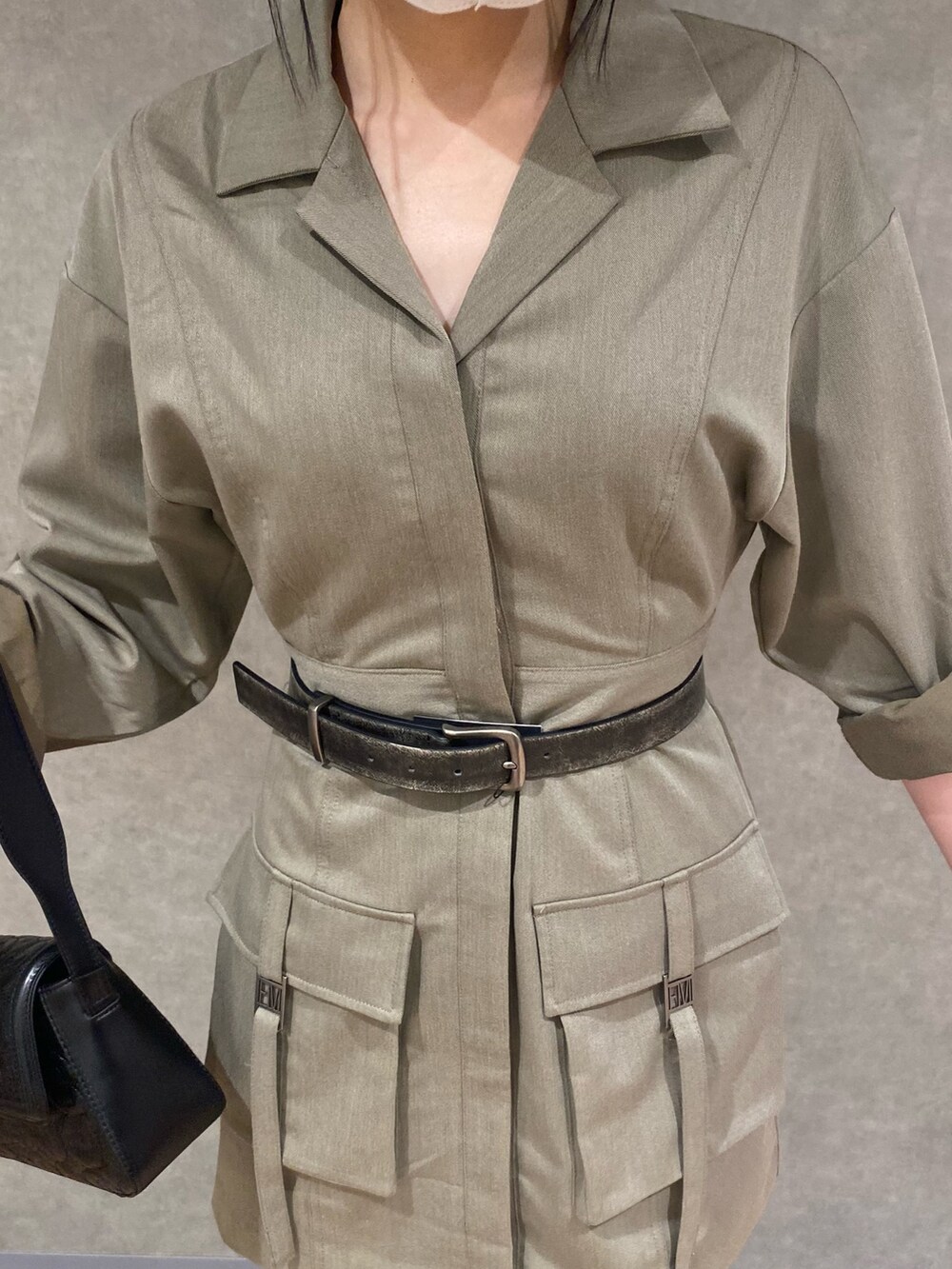 ブラック系のブーツ、ブラック系のハンドバッグ、ベージュ系のワンピースを着用したレディースの秋コーディネートの4枚目の写真